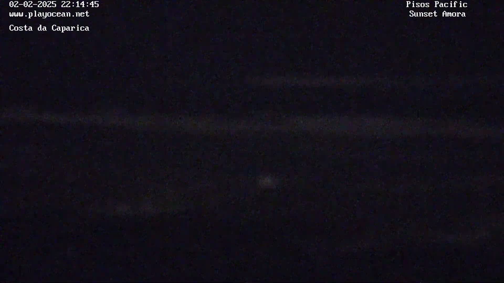 A dark, nighttime image shows a mostly black ocean with faint, horizontal lines suggesting waves under a dark sky.
