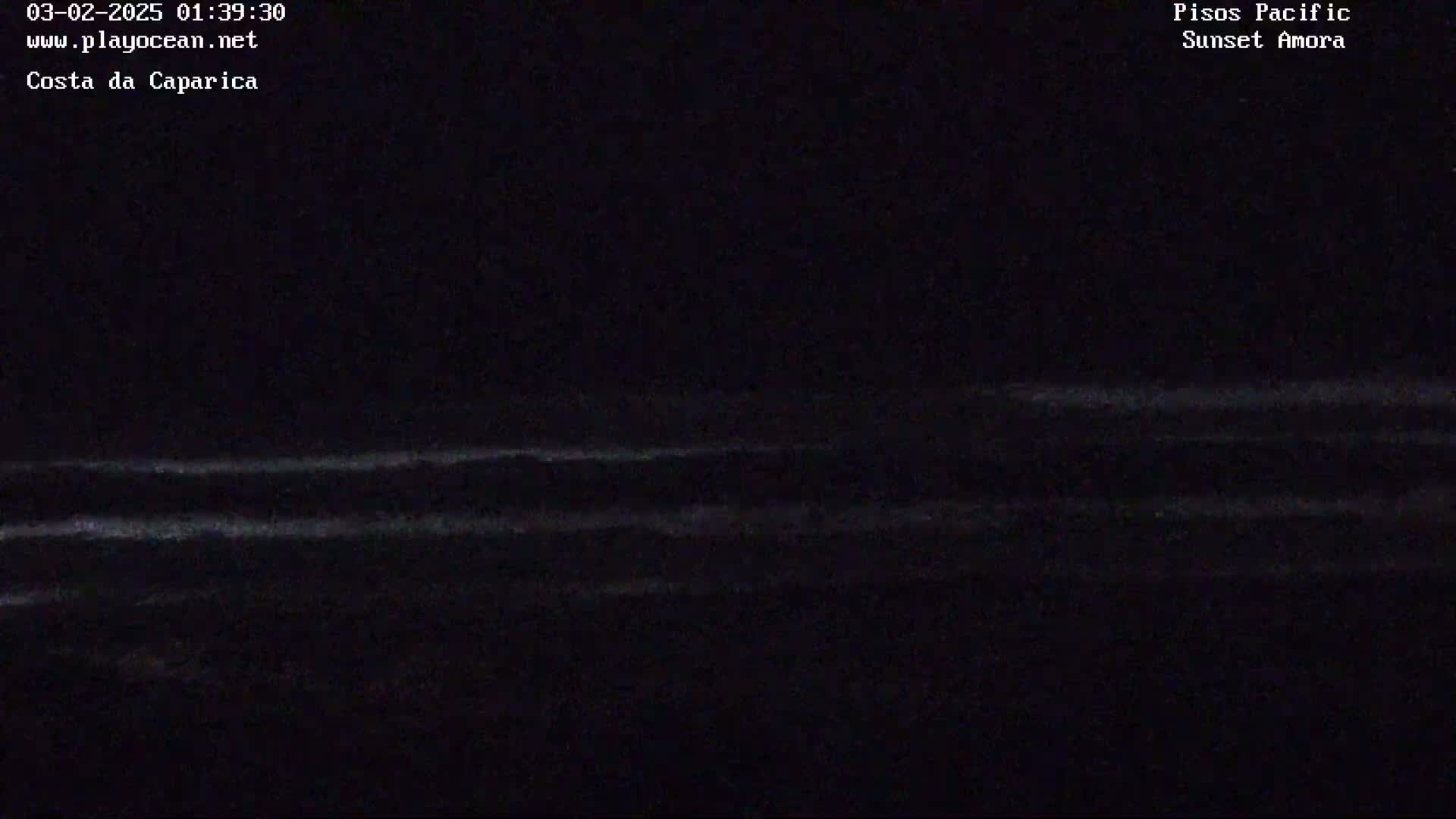 A nighttime ocean scene shows dark water with faint, barely visible waves under a dark sky.
