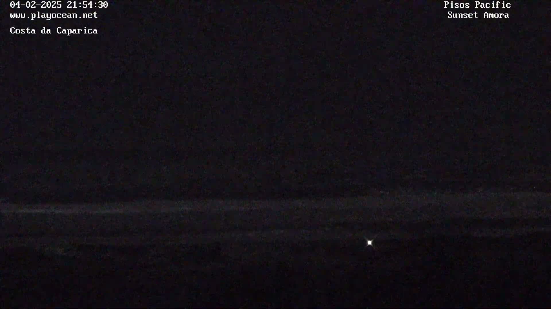 A dark, nighttime scene shows a faint horizon line with a single, small light source visible in the distance.