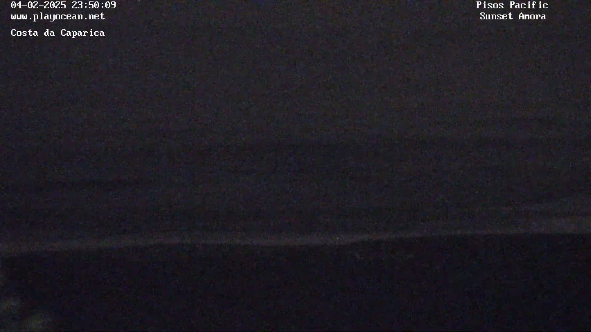 A dark, nighttime image shows a mostly black ocean with a faint horizon line.