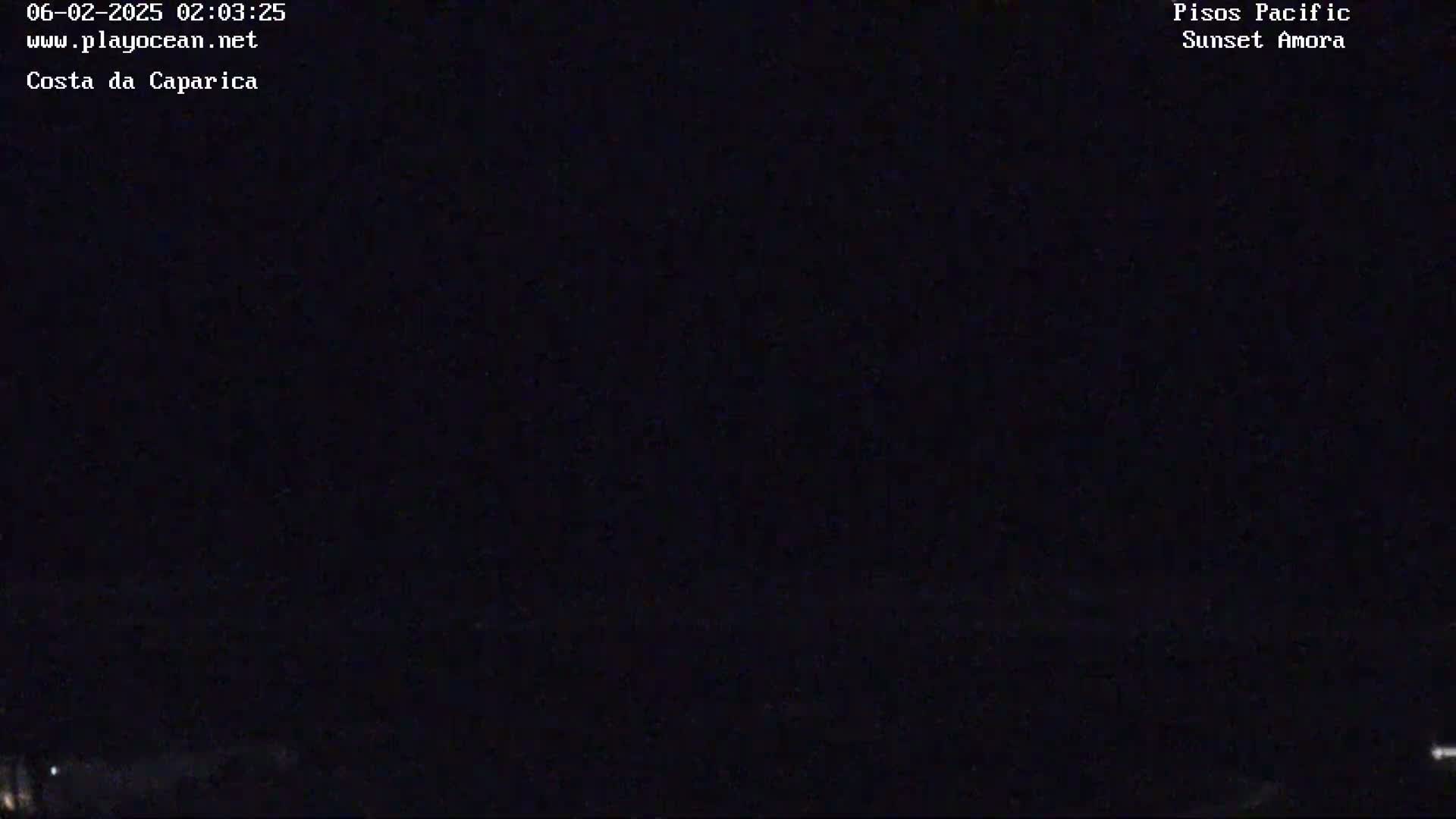 The image shows a completely dark nighttime scene with minimal light visible on the horizon.