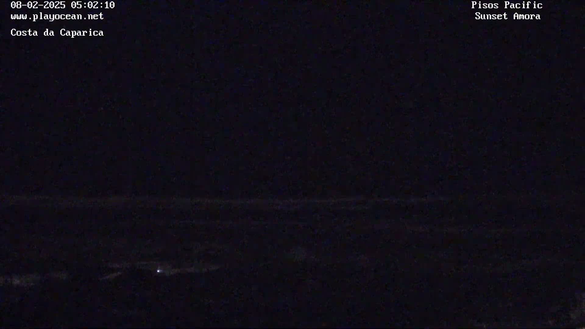 A dark, nighttime scene shows a barely visible horizon line over the ocean.