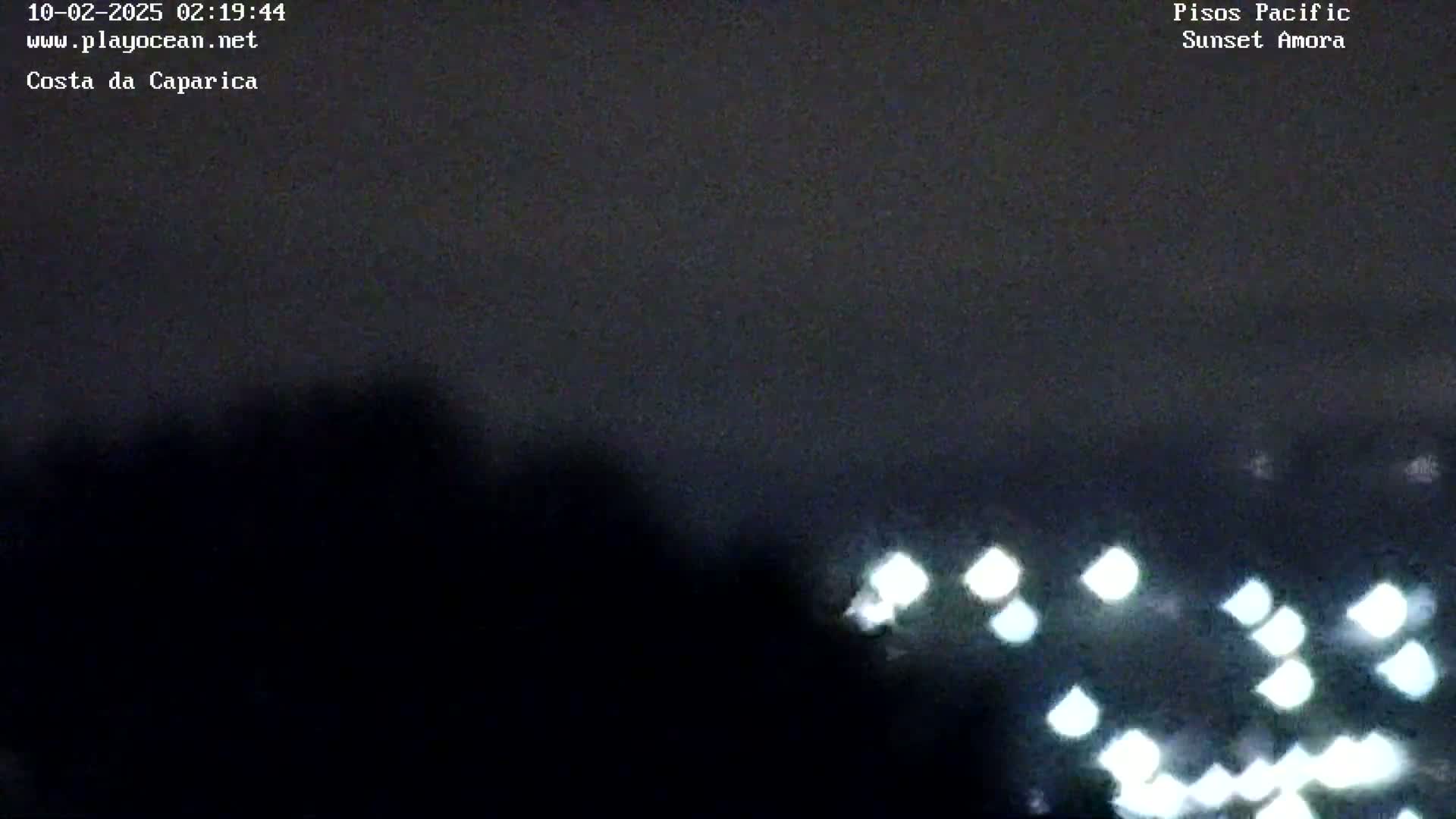 A nighttime, overcast view shows blurred lights in the distance.