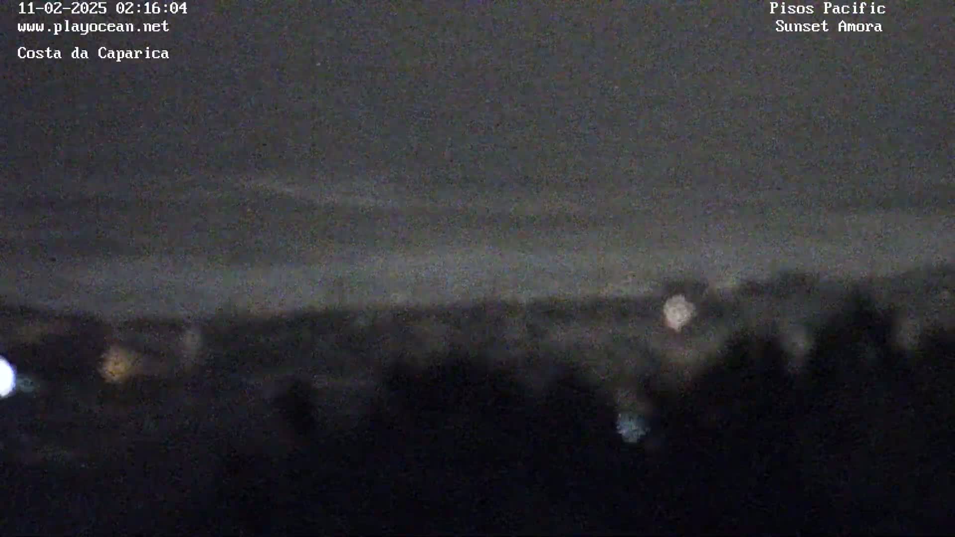 A nighttime, blurry long shot shows a dark landscape with a few distant lights and a hazy sky.