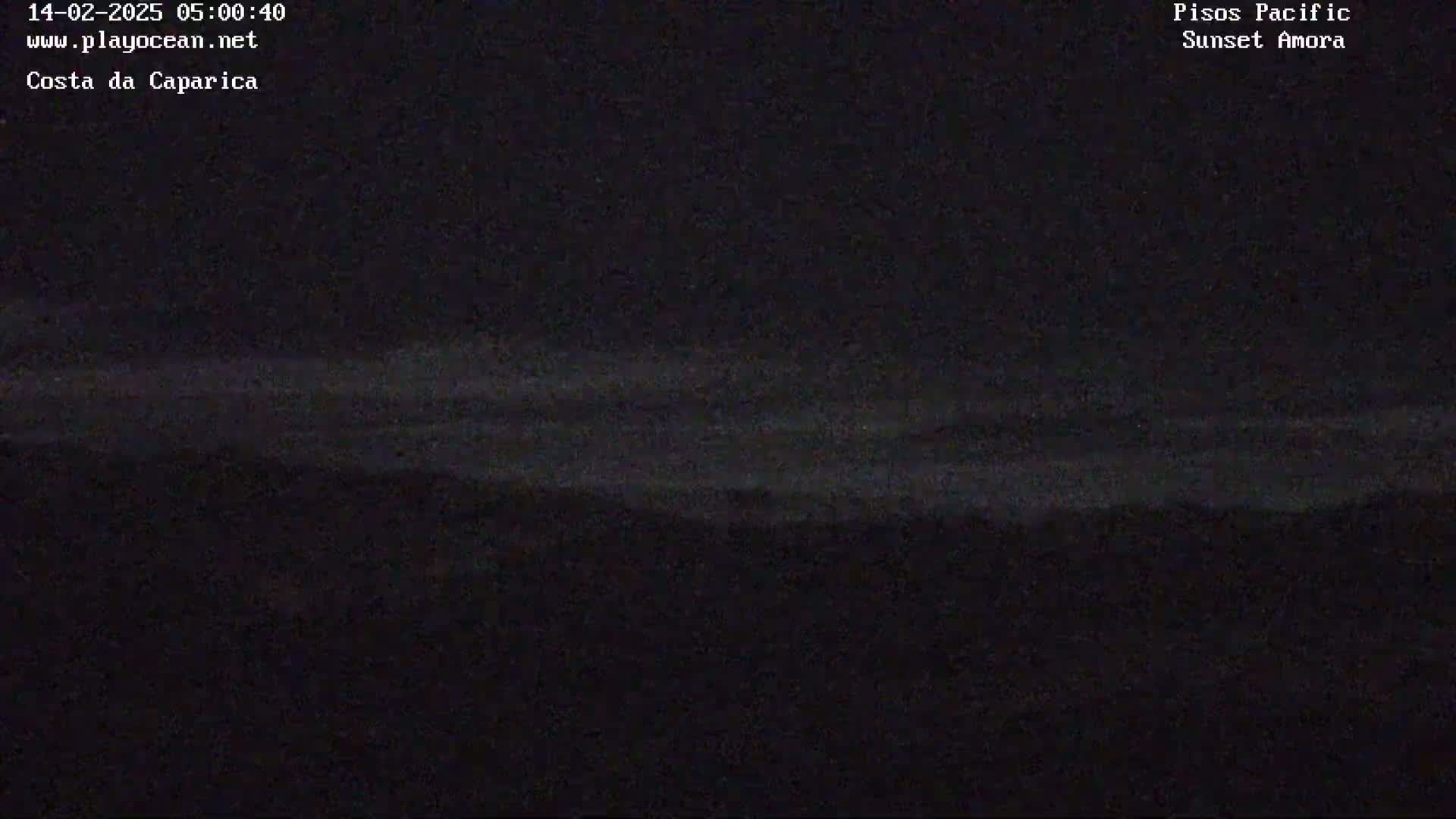 A dark, nighttime landscape shows a faint, horizontal band of lighter gray across a mostly black sky above a dark horizon.