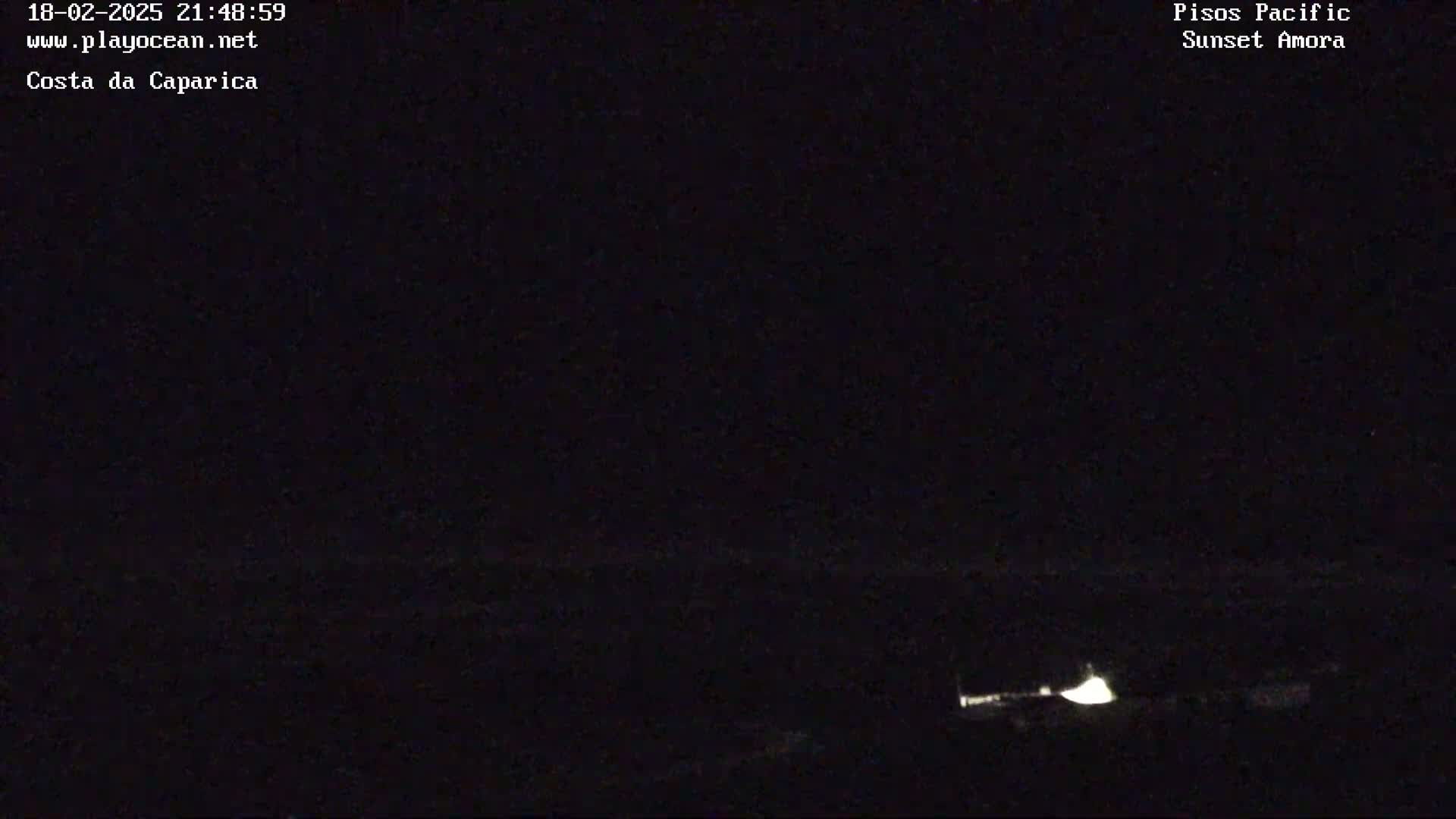 A dark, nighttime scene shows a faint light source near the bottom right corner of the frame.
