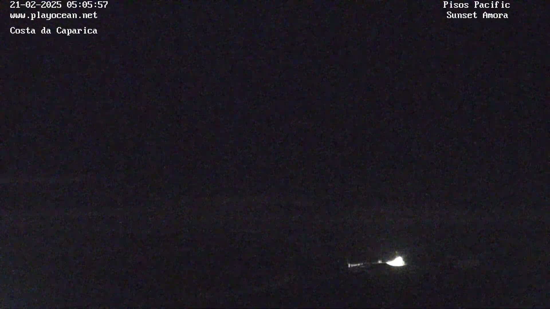 A dark, nighttime scene shows a faint light source near the bottom of the frame.