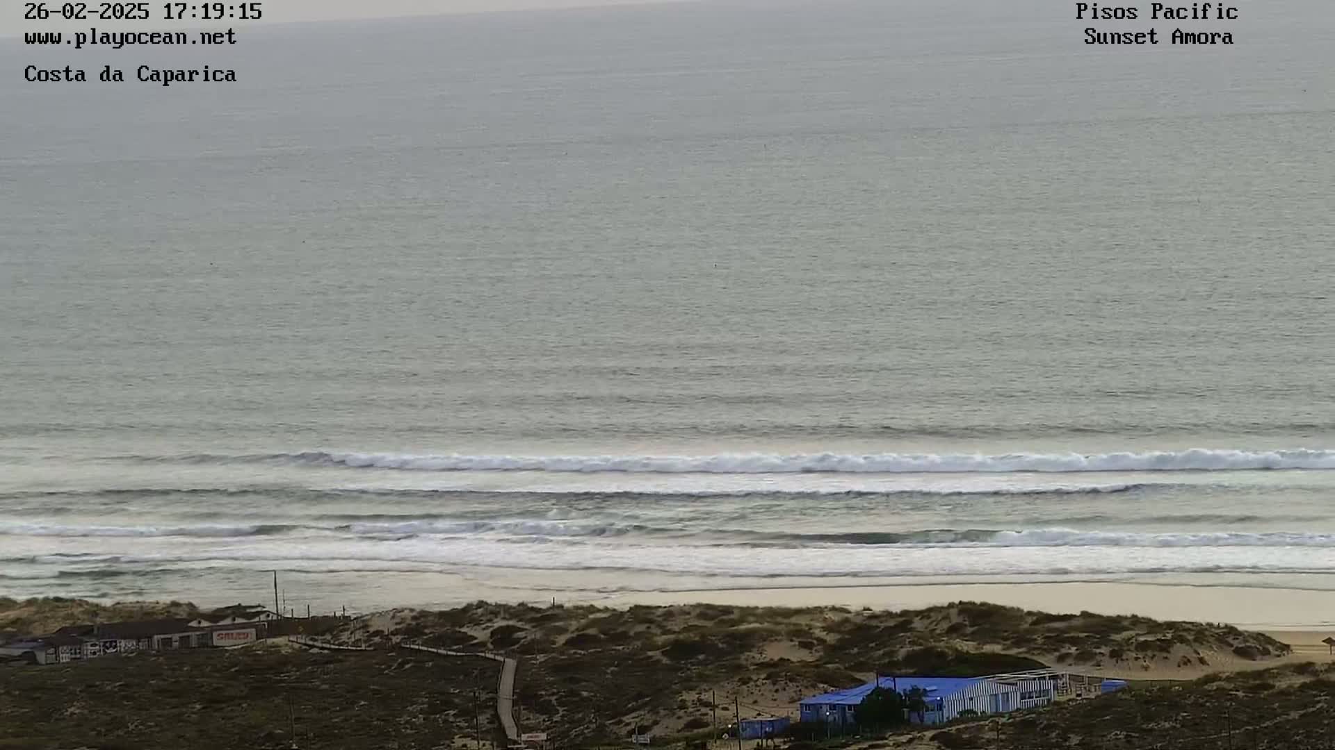 A beach with small waves rolling onto the shore under an overcast sky.
