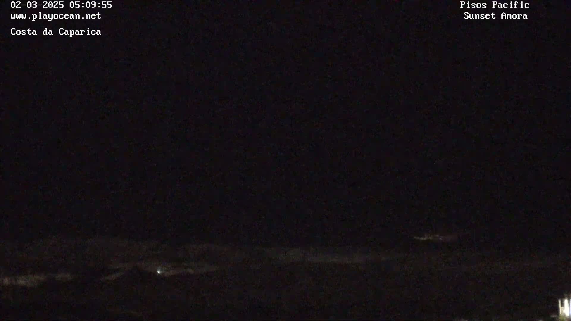 A dark nighttime scene shows a distant, faintly illuminated horizon line with a mostly clear sky.