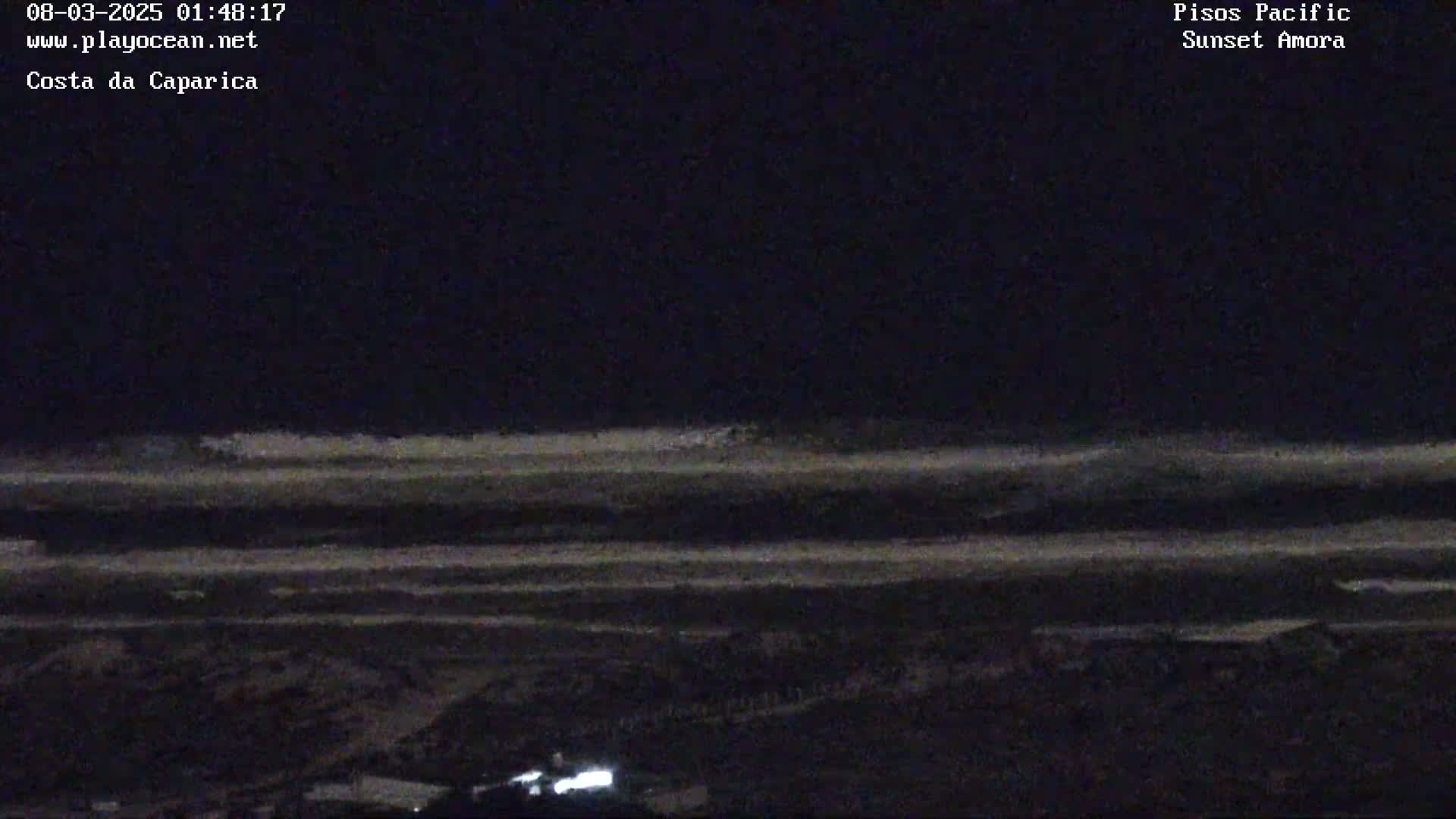 A nighttime long shot shows dark sand and a dark ocean with faint waves under a dark sky.