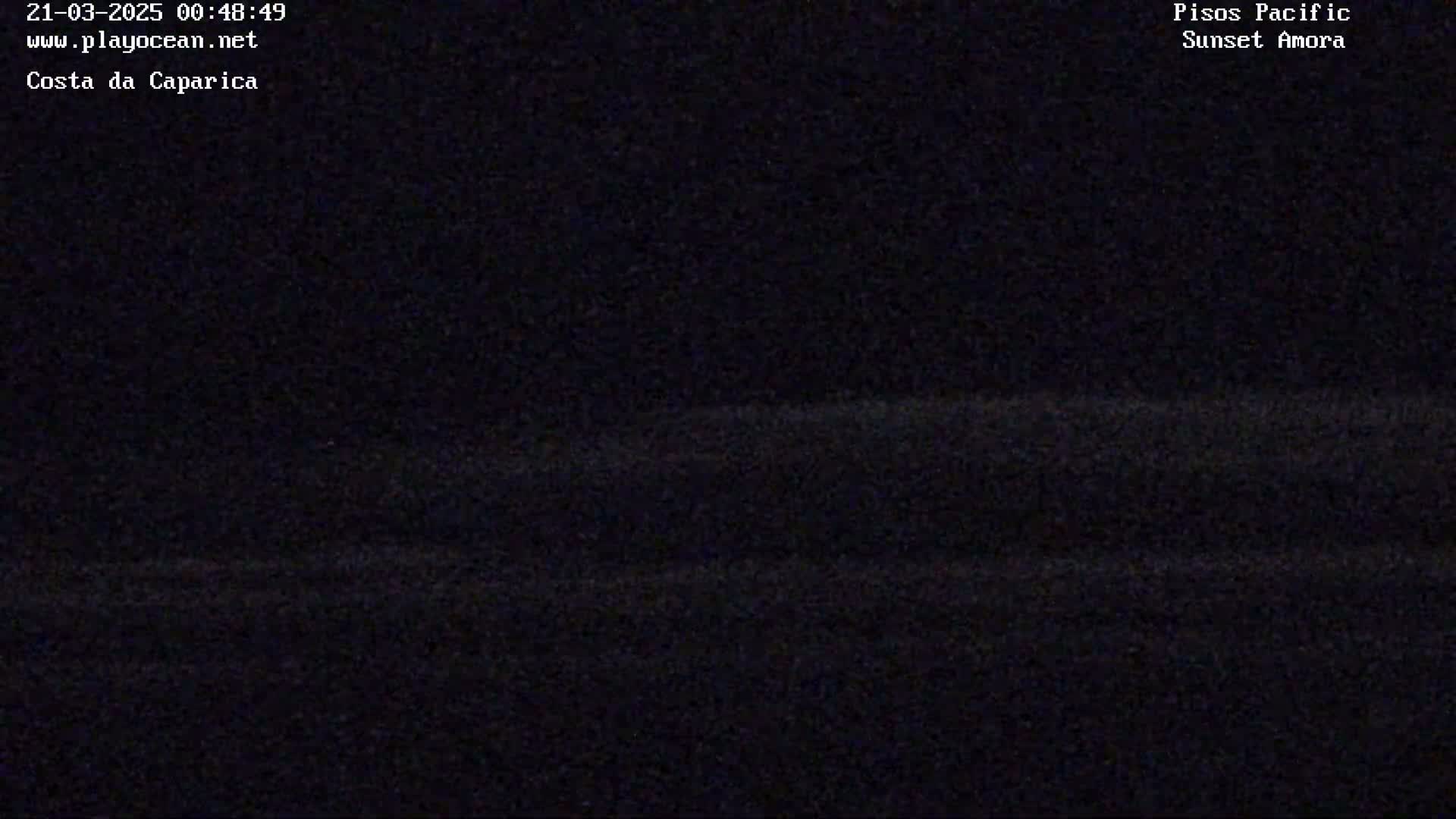 A dark, nighttime view of a wavy, indistinct landscape.