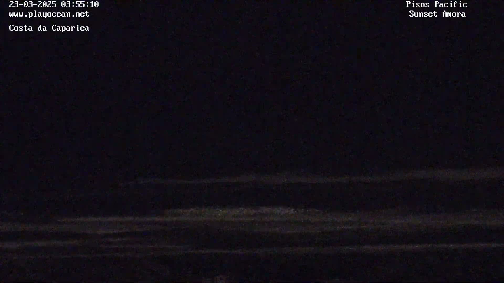 A dark nighttime scene shows a mostly black ocean with faint, horizontal lines suggesting waves under a dark sky.
