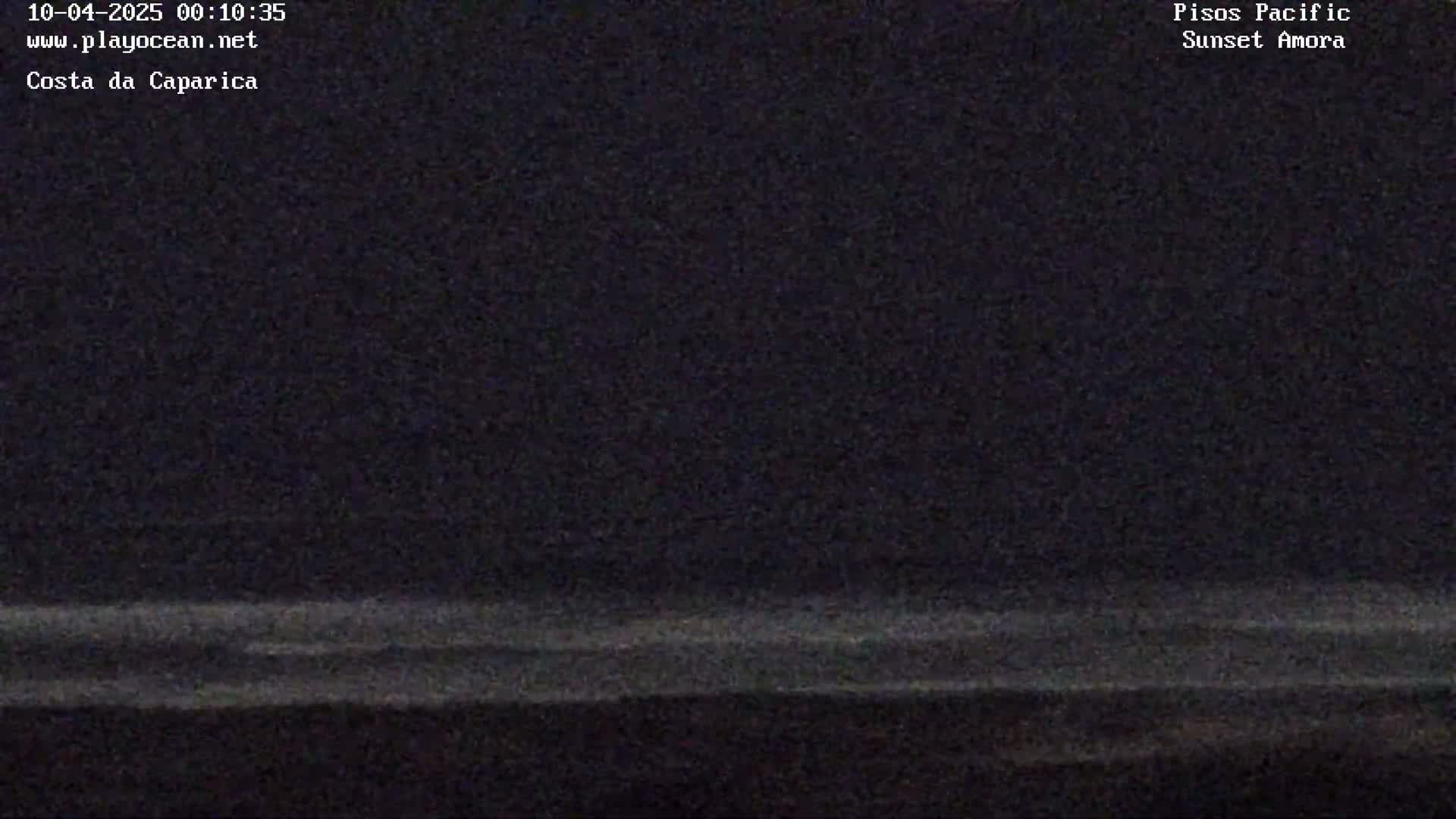 A dark, nighttime image shows a faint, light-colored horizon line over a dark body of water.