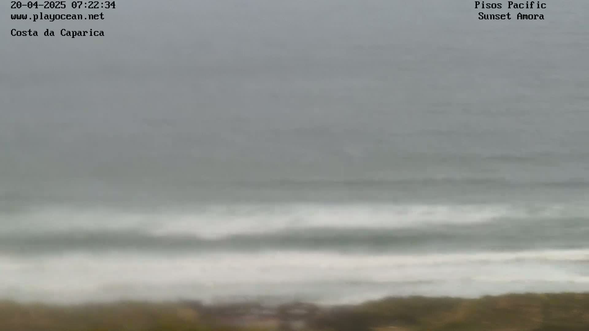 A long shot of an overcast ocean with waves breaking near the shore.