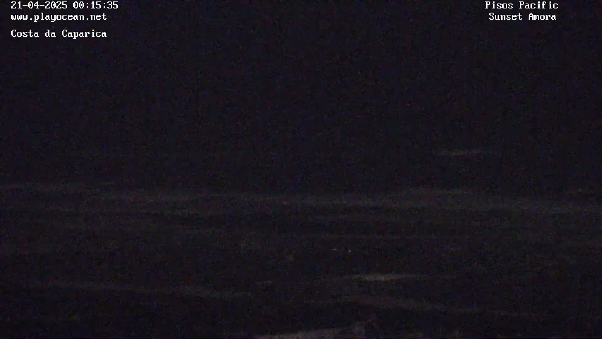 A dark, nighttime view of a seemingly calm body of water under a clear, starless sky.