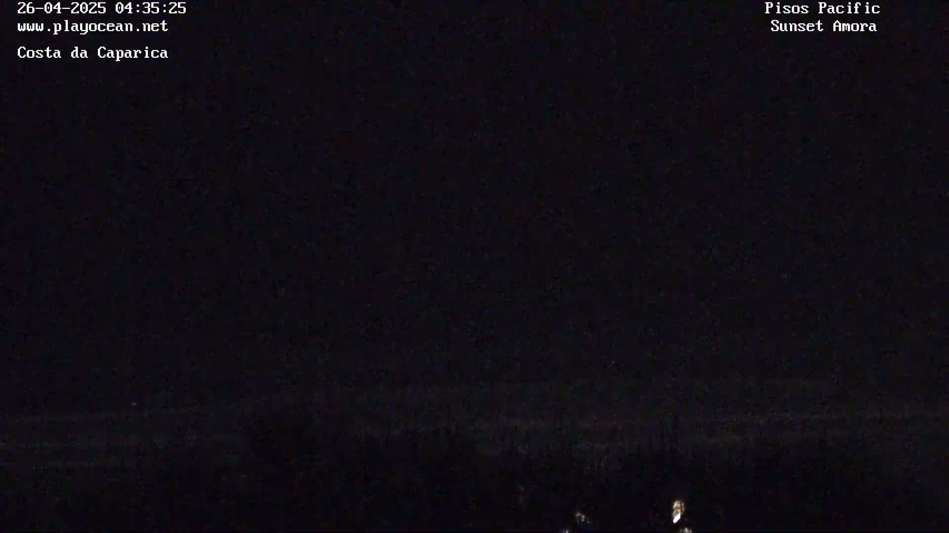A dark, nighttime scene shows a mostly black landscape with a faint, indistinct horizon line.