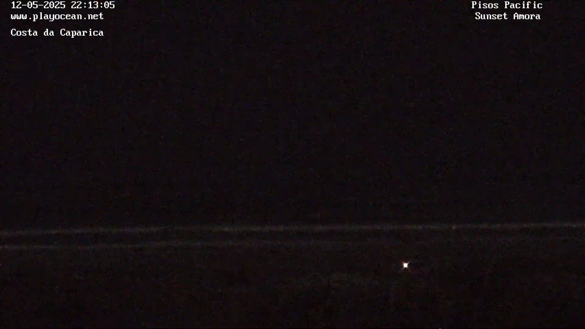A dark nighttime scene shows a faint horizon line and a single small light source in the distance.