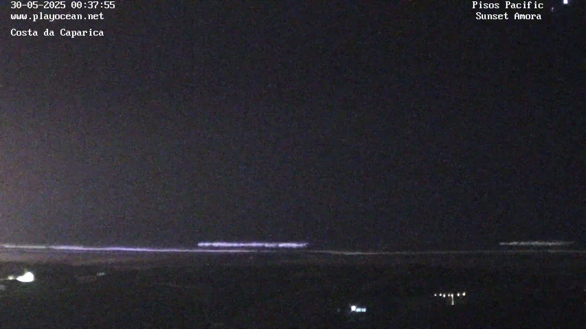 A dark nighttime ocean beach scene is visible under a clear, dark sky.