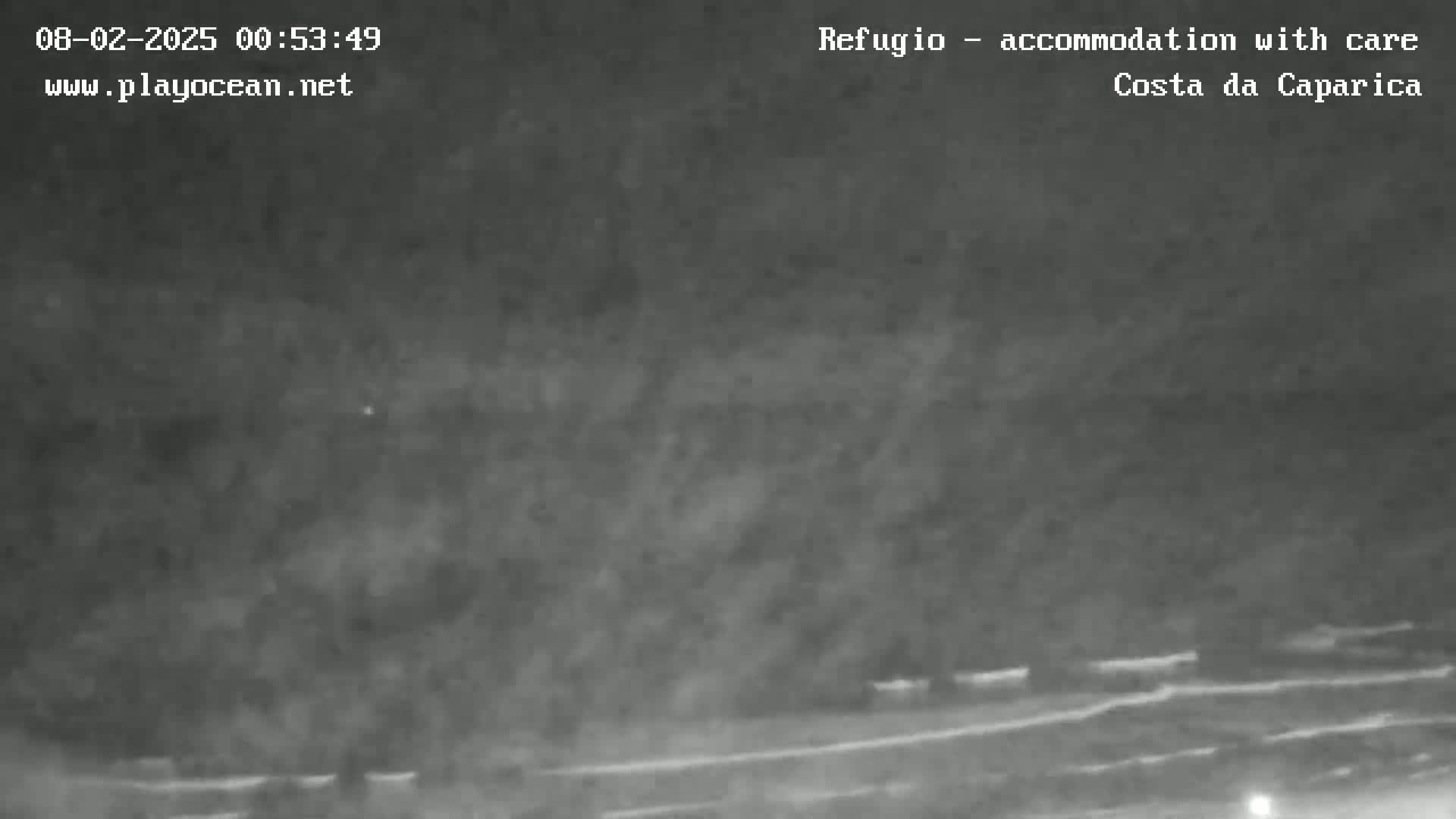 A nighttime, low-visibility image shows a dark, possibly foggy or hazy landscape with a faint horizontal line suggesting a shoreline or road in the lower portion.