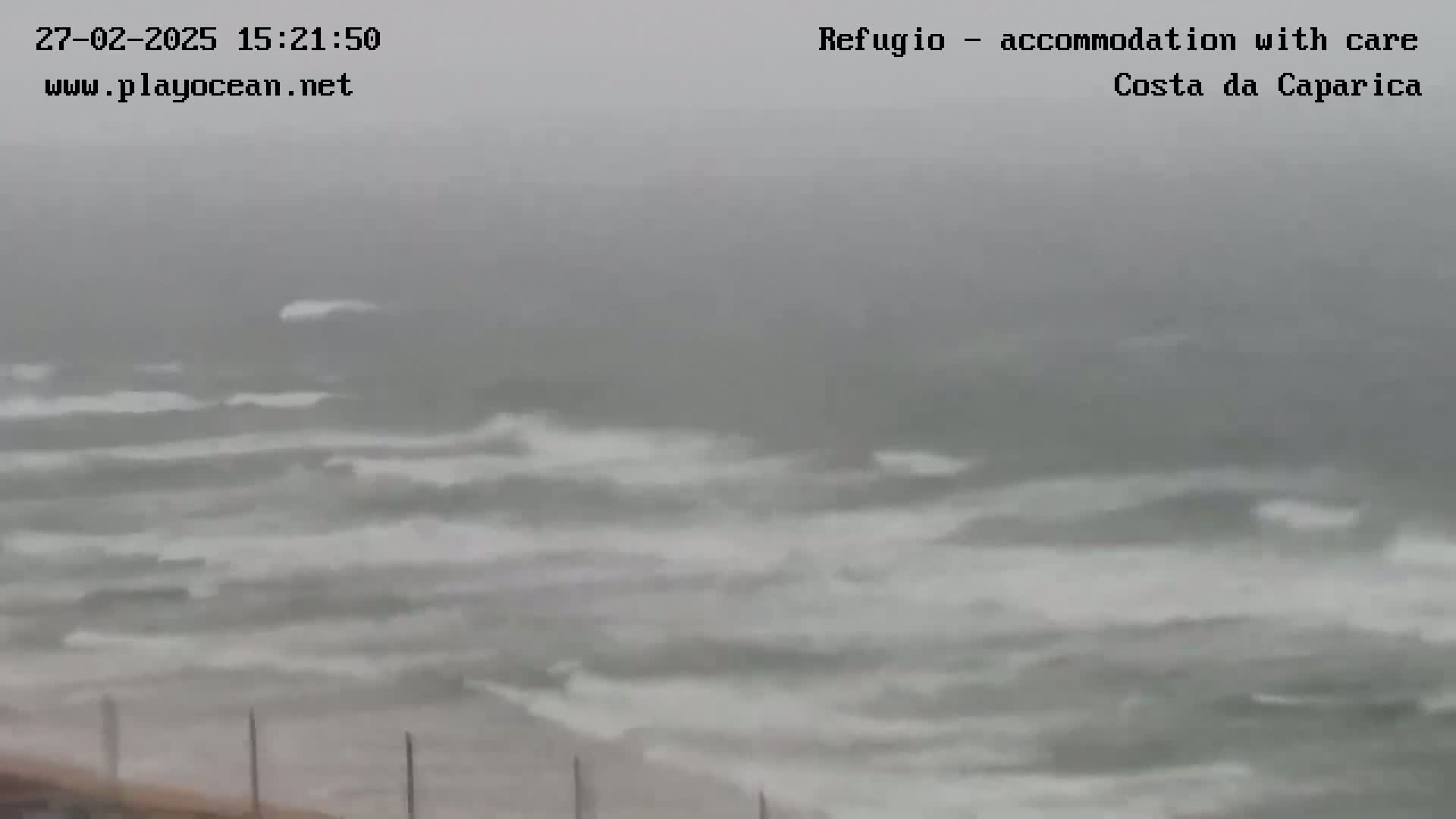 A choppy, gray sea with whitecaps is seen from a coastal vantage point on an overcast day.