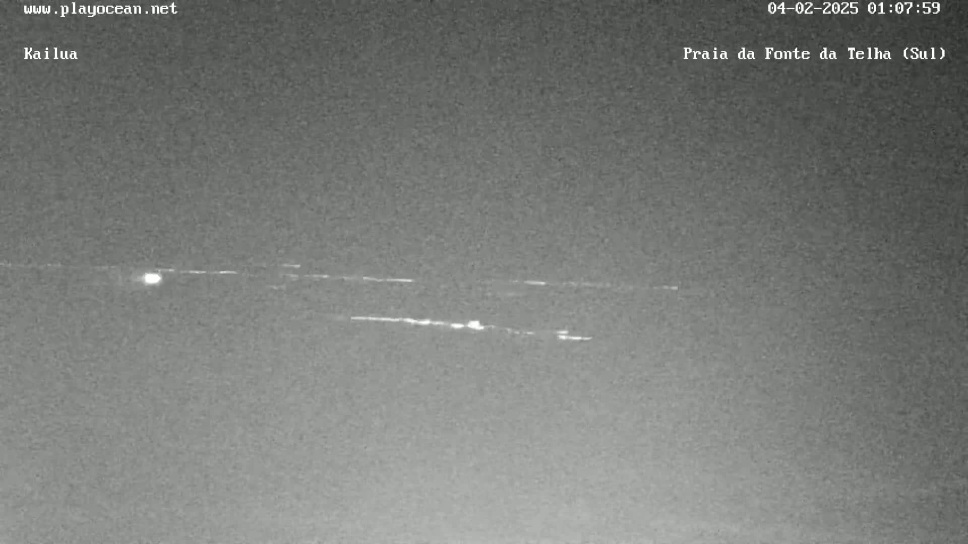 A nighttime, low-light image shows several faint, horizontal streaks of light against a dark gray sky.