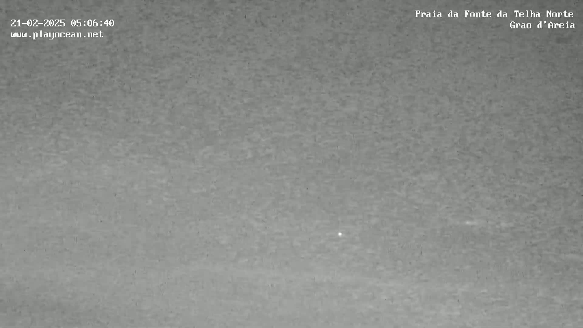 A low-light, grainy image shows an overcast sky.