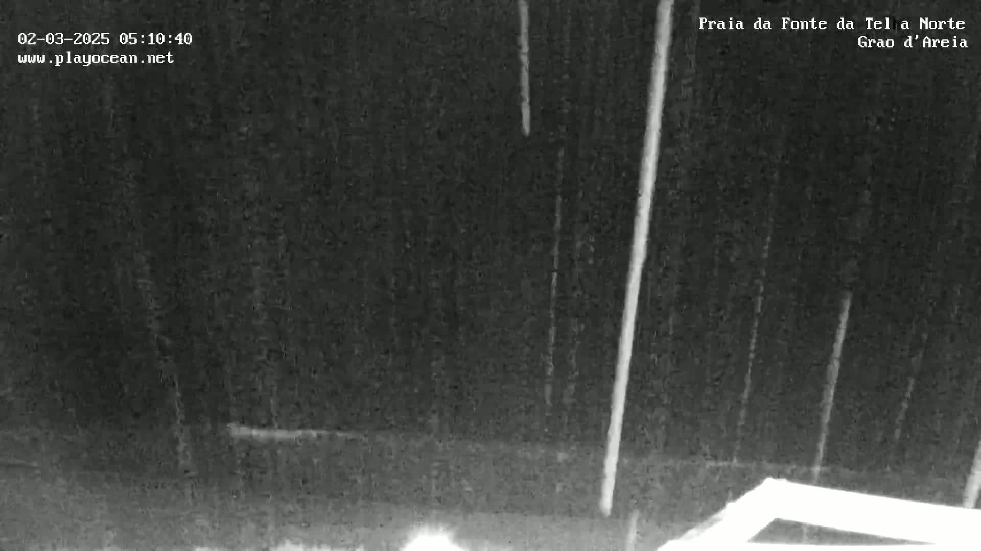A nighttime outdoor scene shows heavy rain falling.