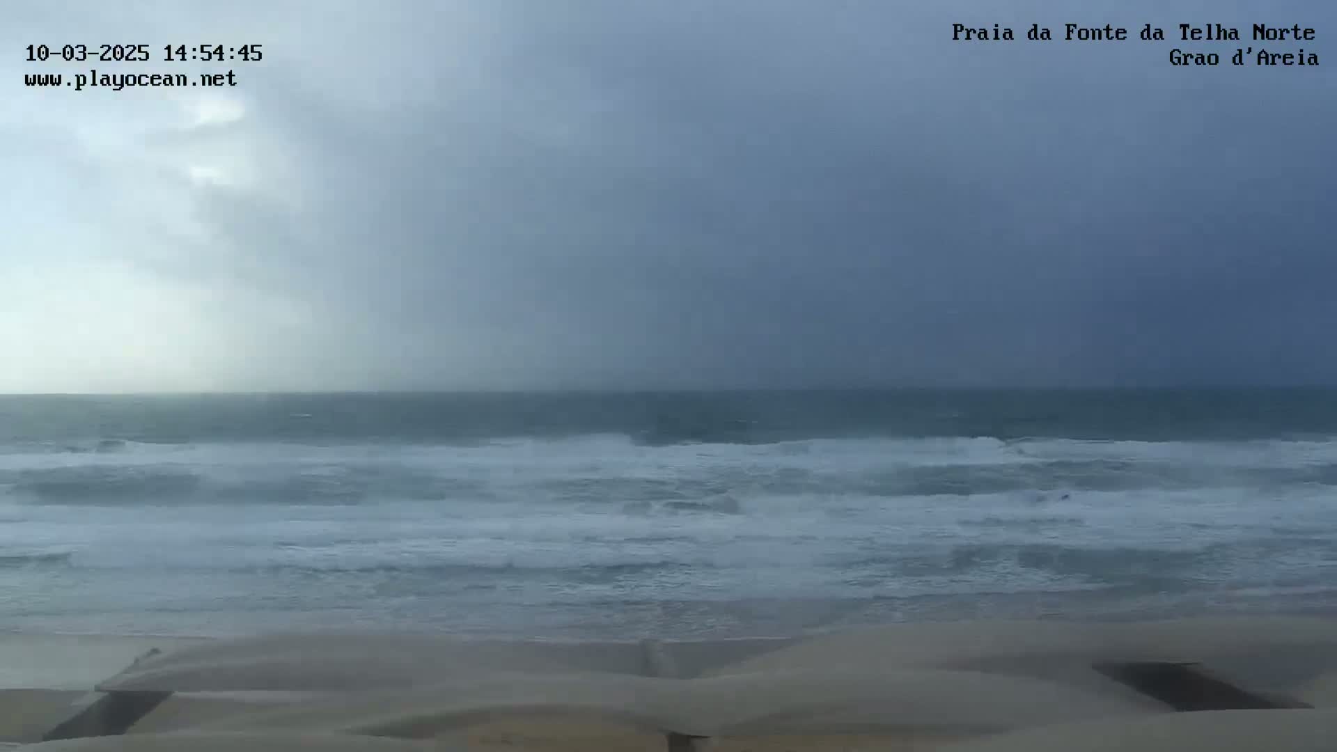 A beach with choppy waves under an overcast sky.
