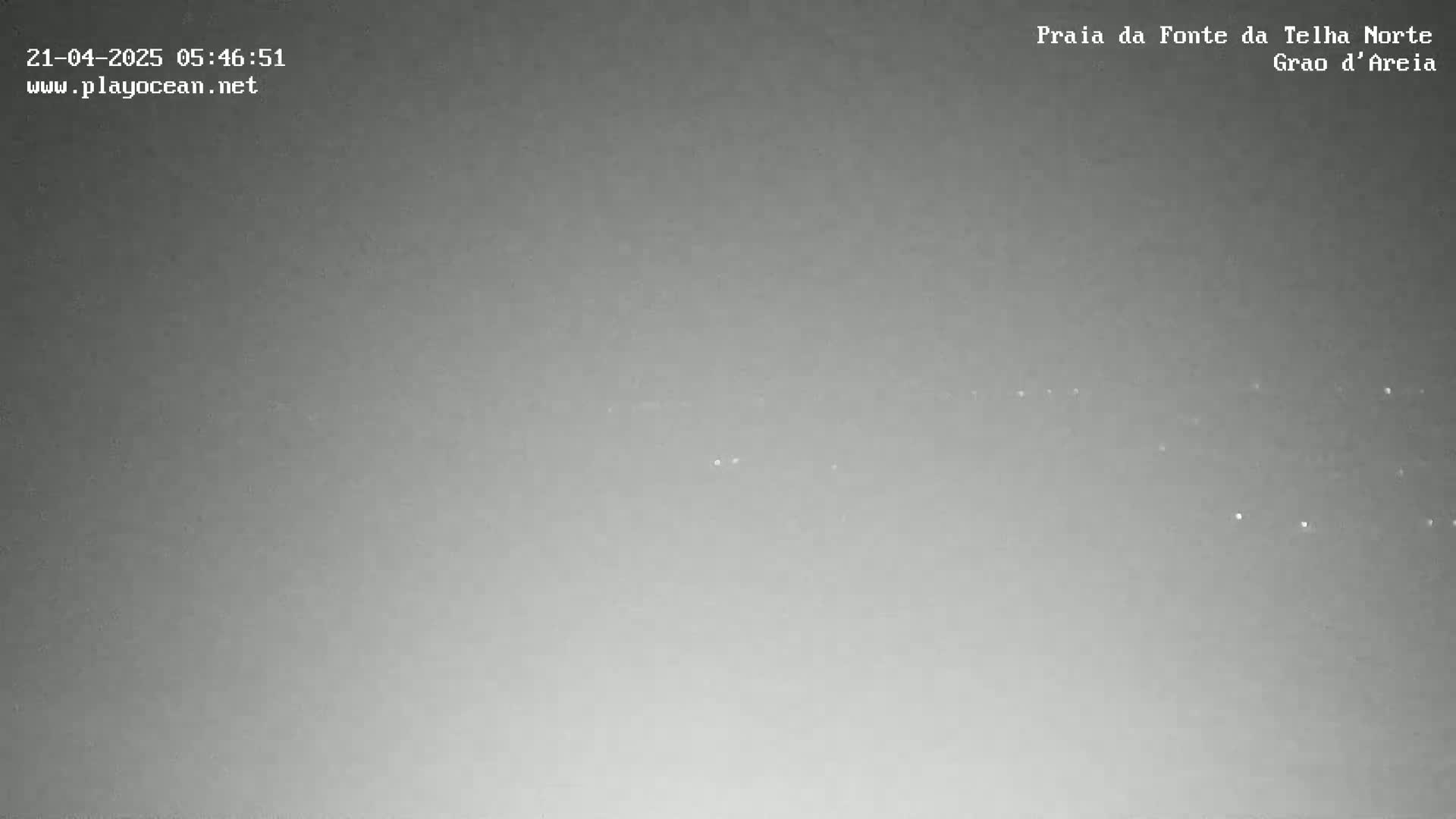 A nighttime, overcast sky shows a few distant lights.