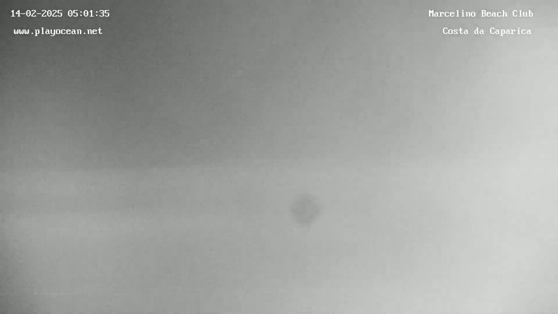 A mostly overcast, gray sky is visible, with a small, indistinct dark spot near the center.
