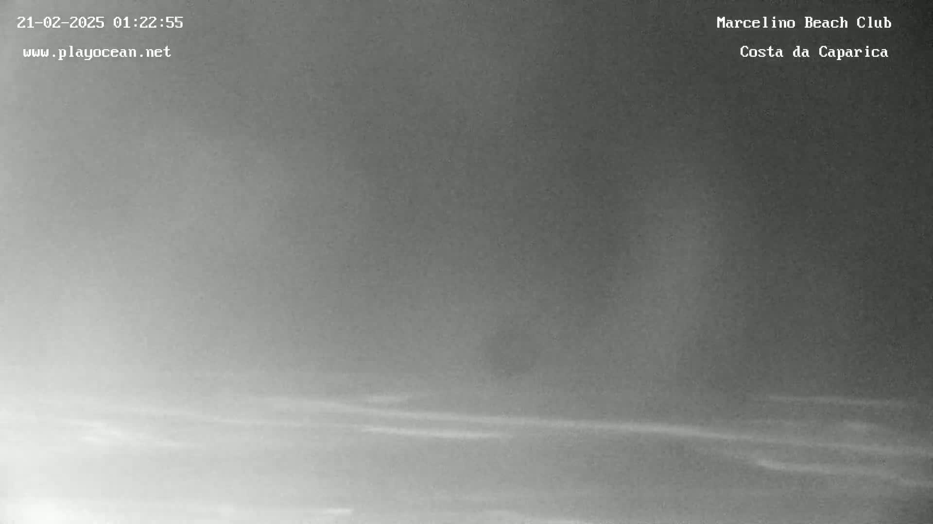 A low-light, nighttime image shows a hazy, possibly foggy beach scene.