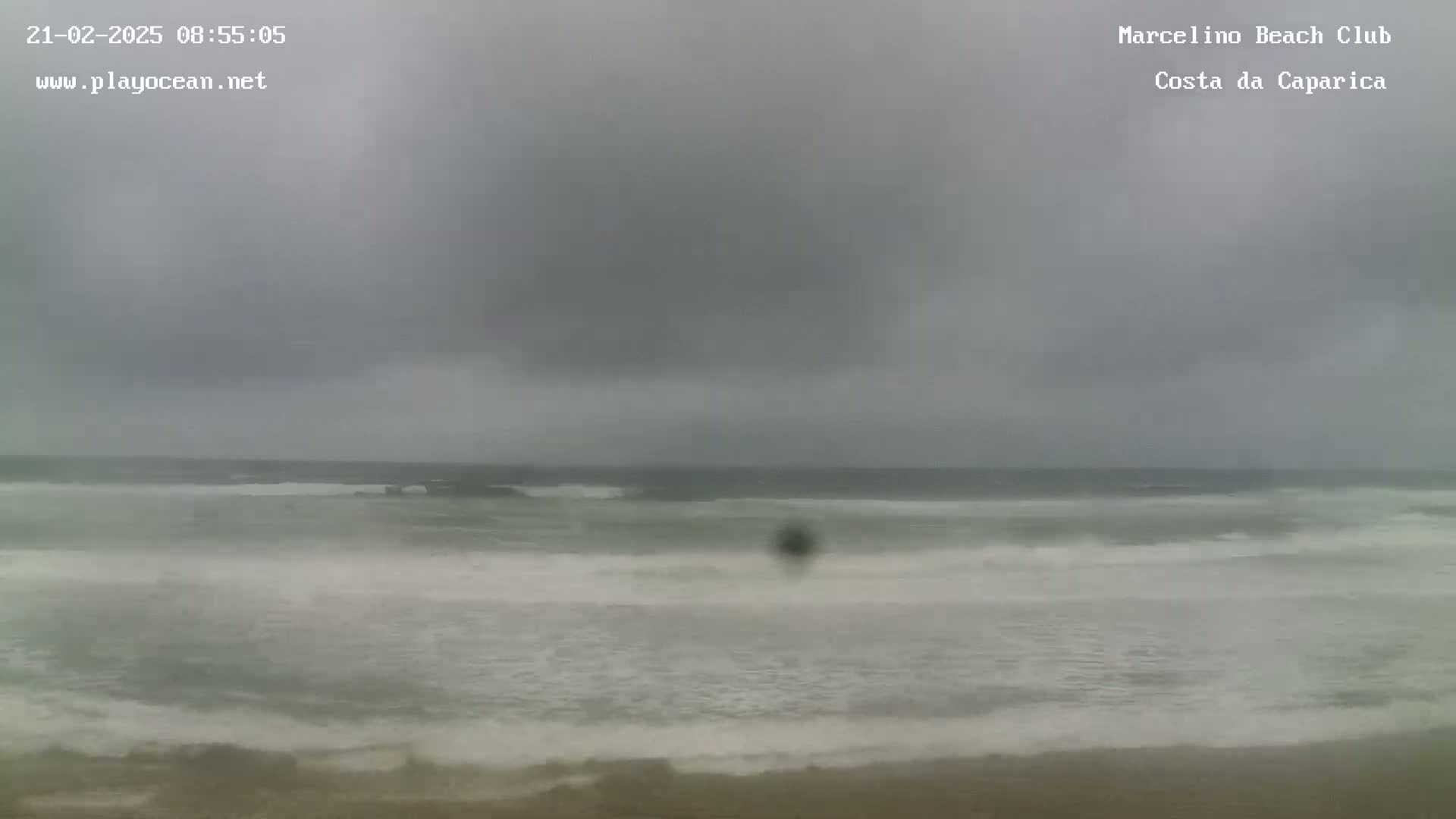 A beach with choppy gray water under an overcast sky.