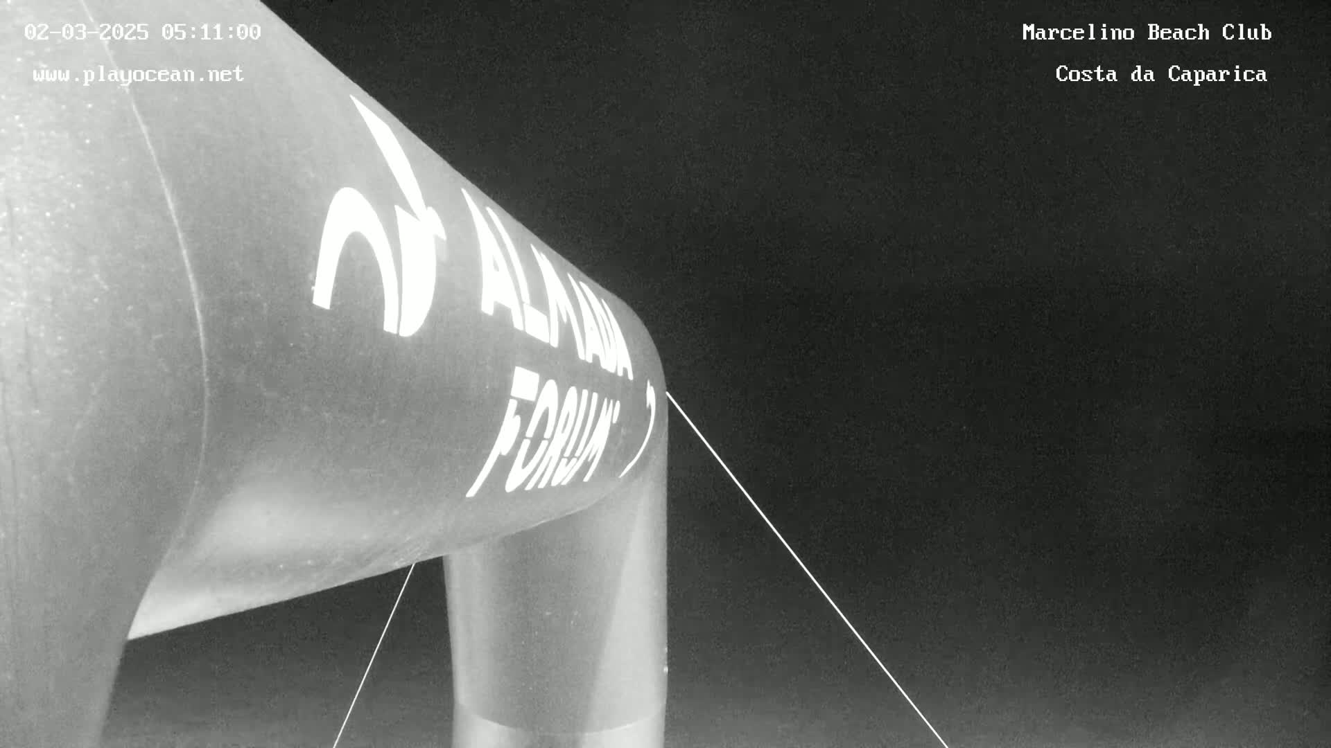 A large inflatable archway, bearing a logo, stands under a dark night sky.