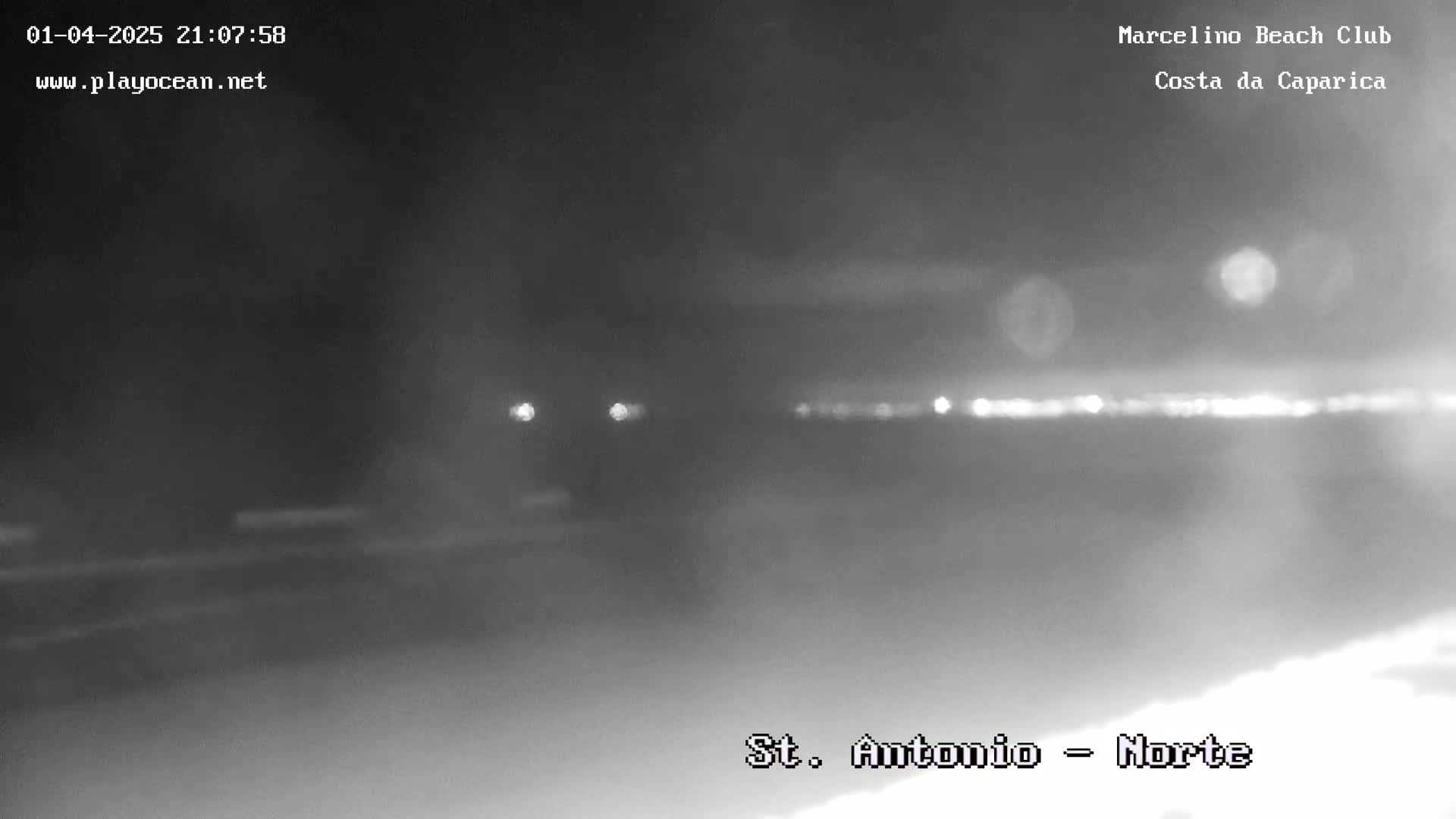 A nighttime, hazy view of a road with distant lights and a blurry horizon.