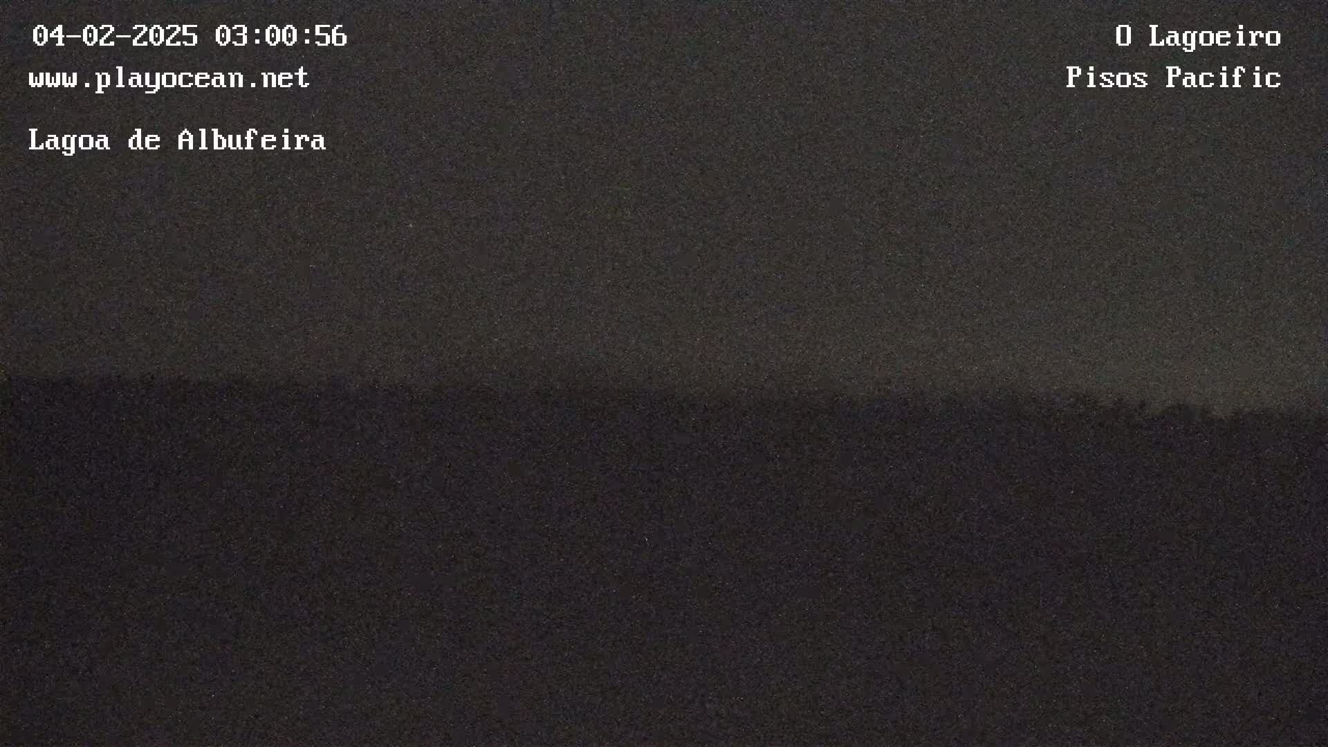 A dark, nighttime view of a flat landscape under a mostly clear sky.