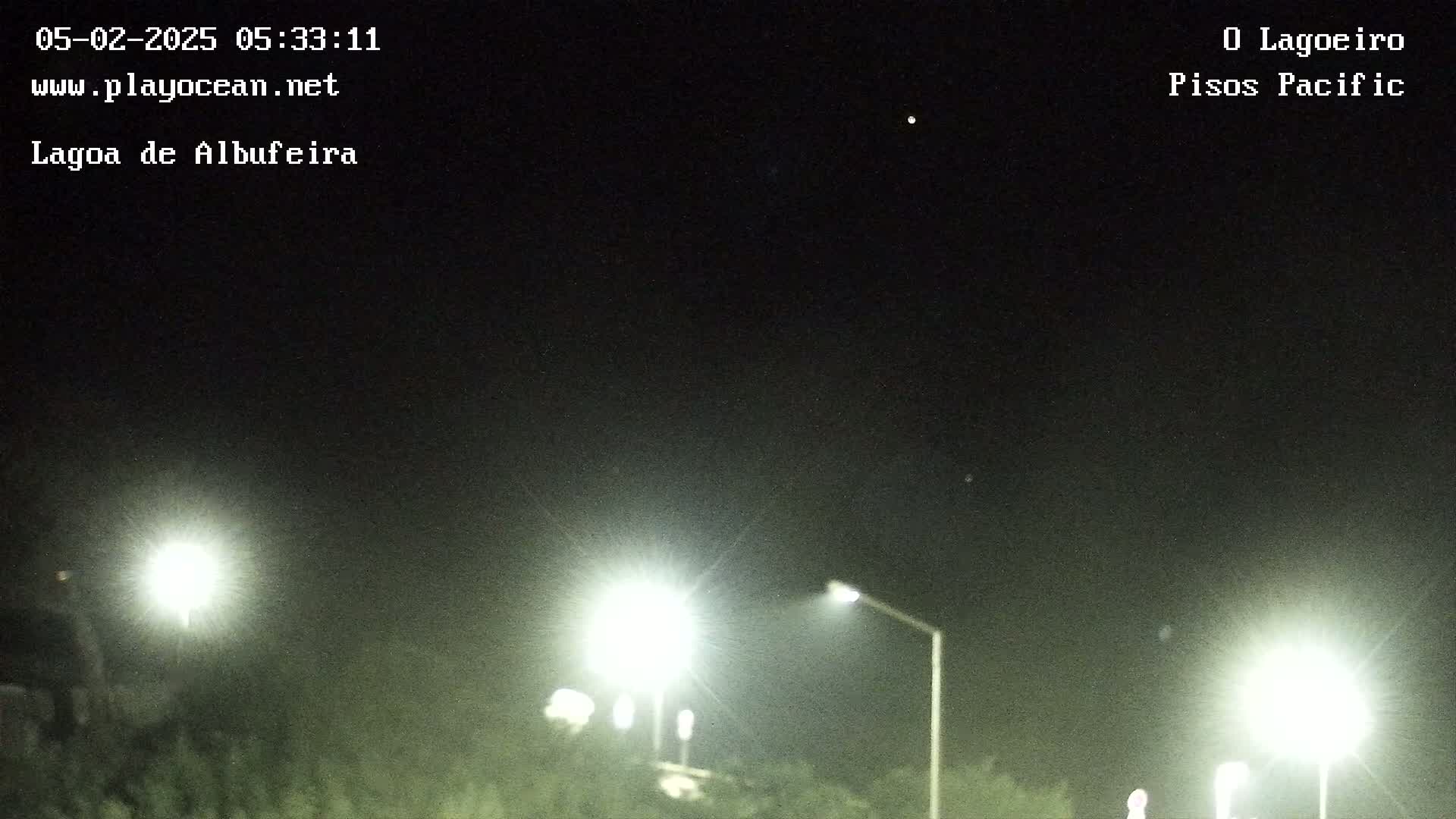 At night, under a clear sky, bright lights illuminate a dark landscape.