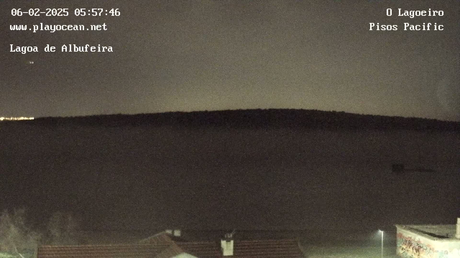A dark, nighttime landscape shows a hill silhouetted against a dusky sky.