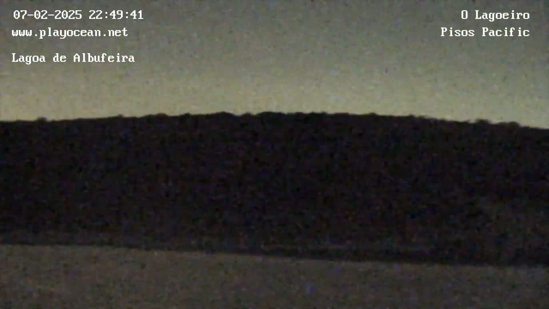 A dark, silhouetted landscape is visible under a twilight sky.