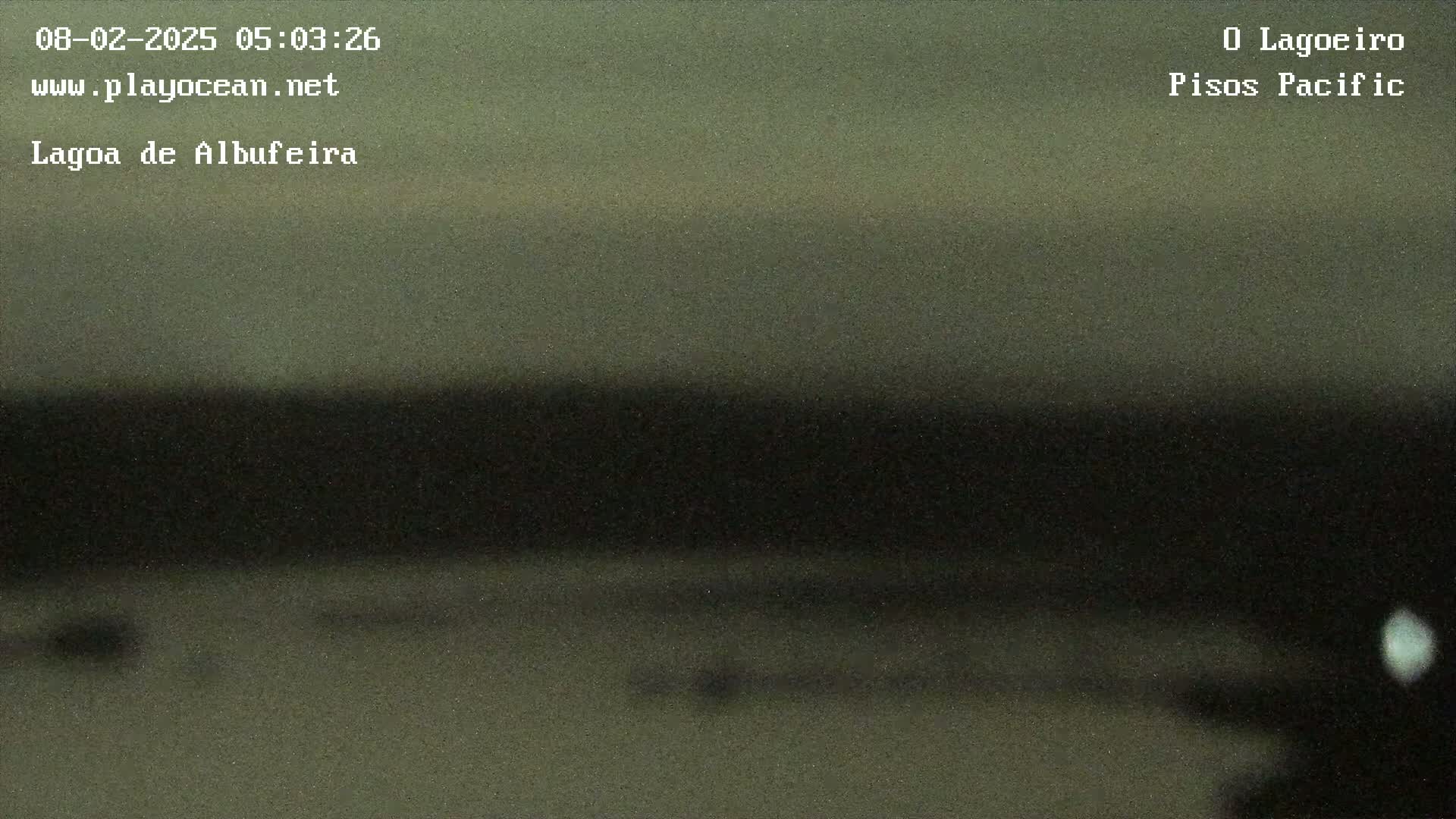 A blurry, dark image shows a body of water under a dusky sky.