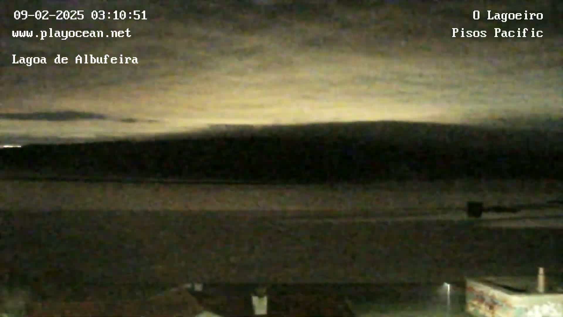 A dark landscape under a cloudy, faintly luminous night sky.