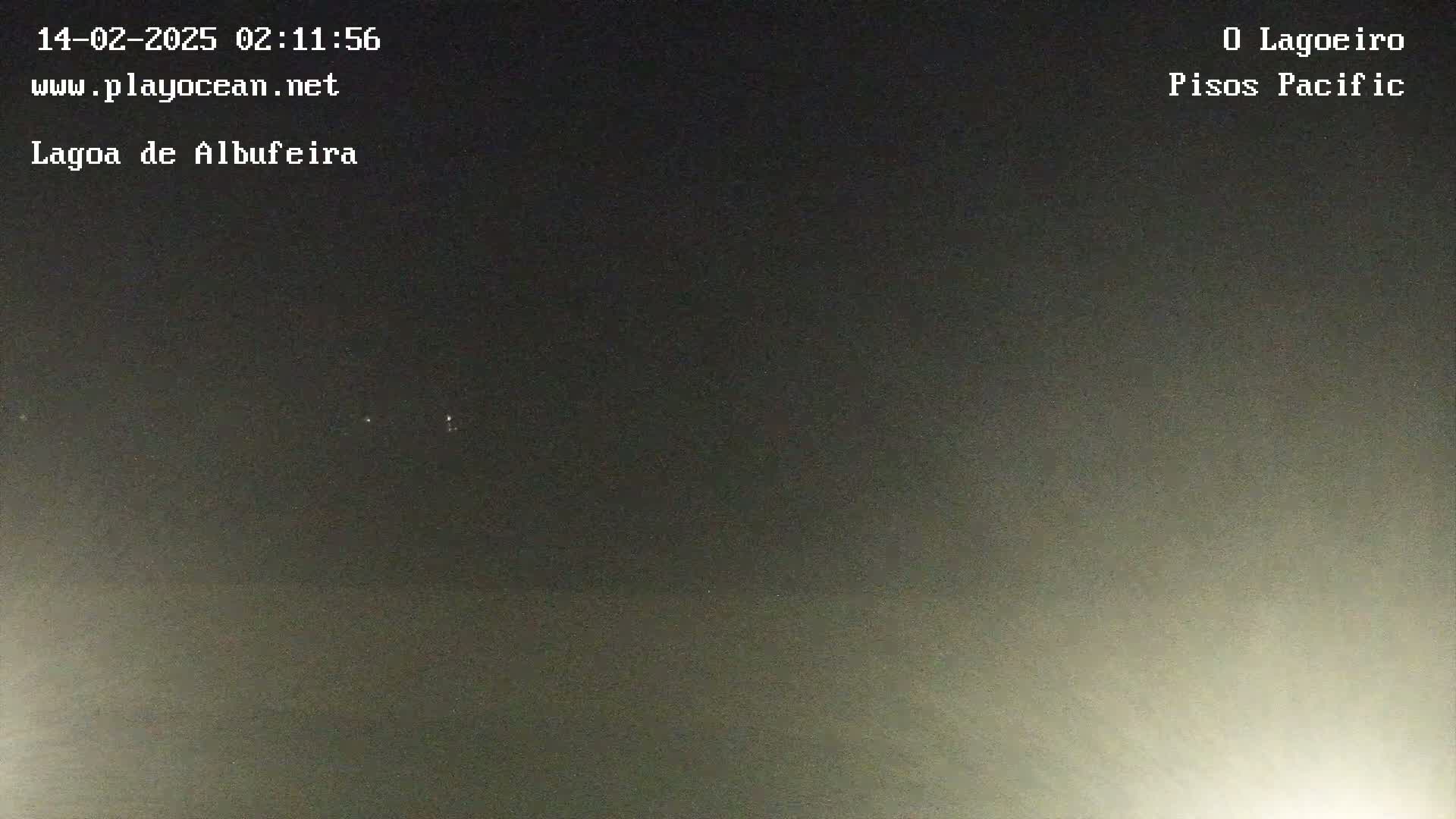 A nighttime, dark-gray sky is visible with a few faint lights in the distance.