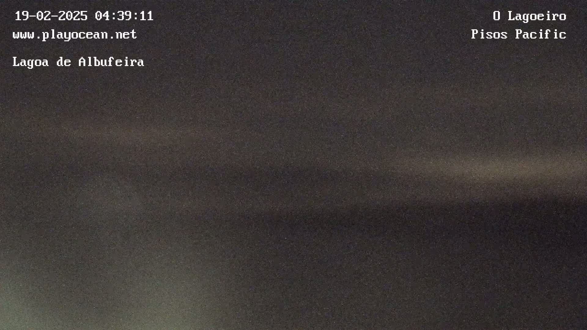 A dark, blurry image shows a body of water at night.