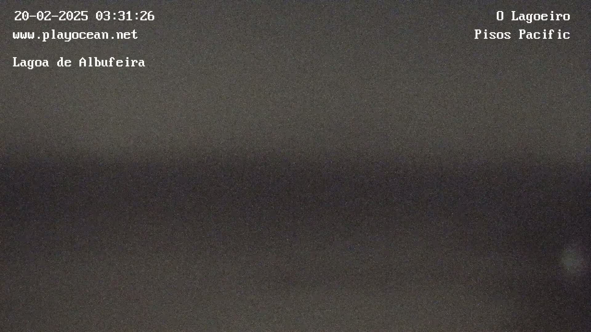 A dark, possibly nighttime, view of a body of water shows a flat, dark surface.