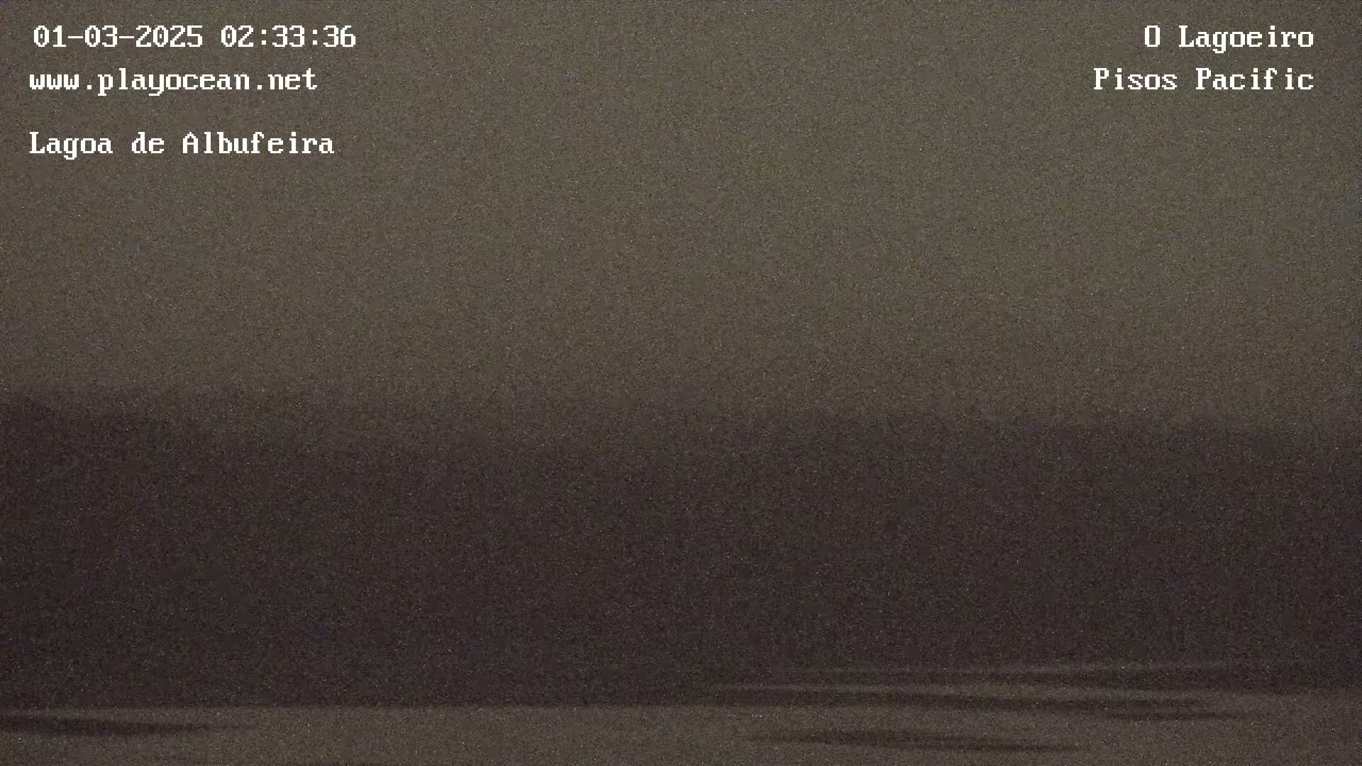 A dark, possibly nighttime, view of a body of water with a dark, indistinct horizon under overcast skies.