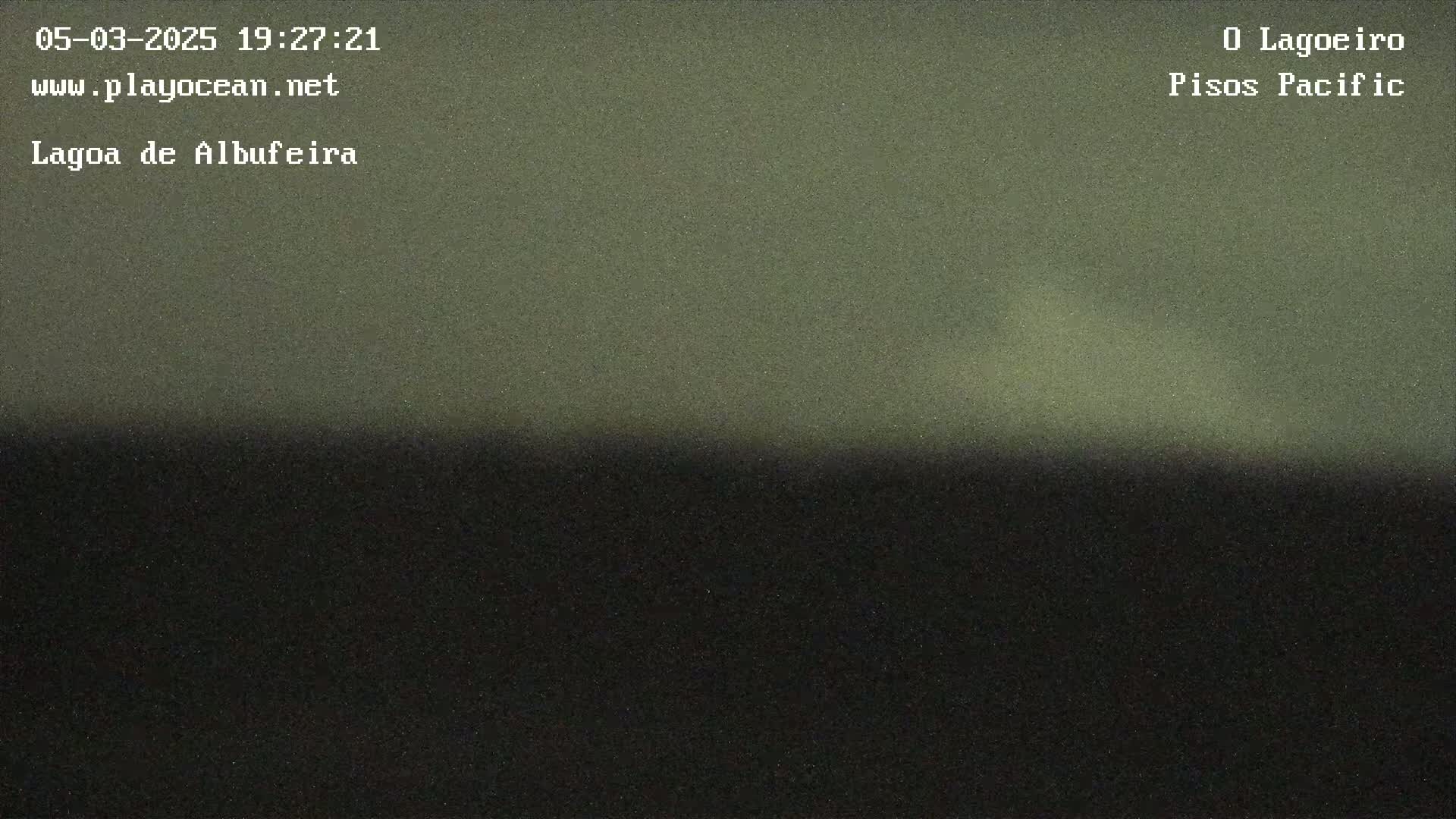 A dark, blurry image shows a dark greenish-gray sky transitioning to a very dark bottom, possibly depicting nighttime land and sky.