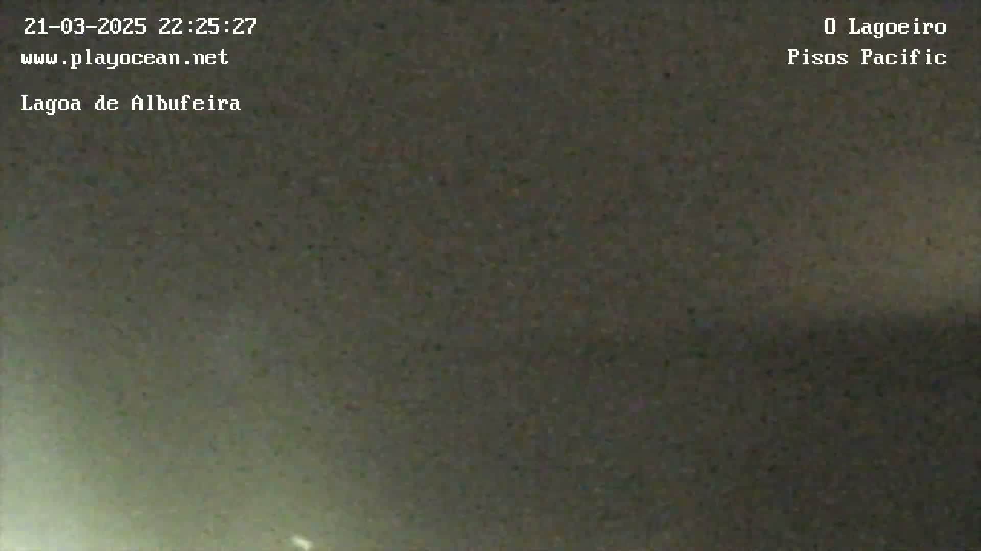 A dark, grainy image shows a mostly featureless night scene with a faint light source at the bottom.