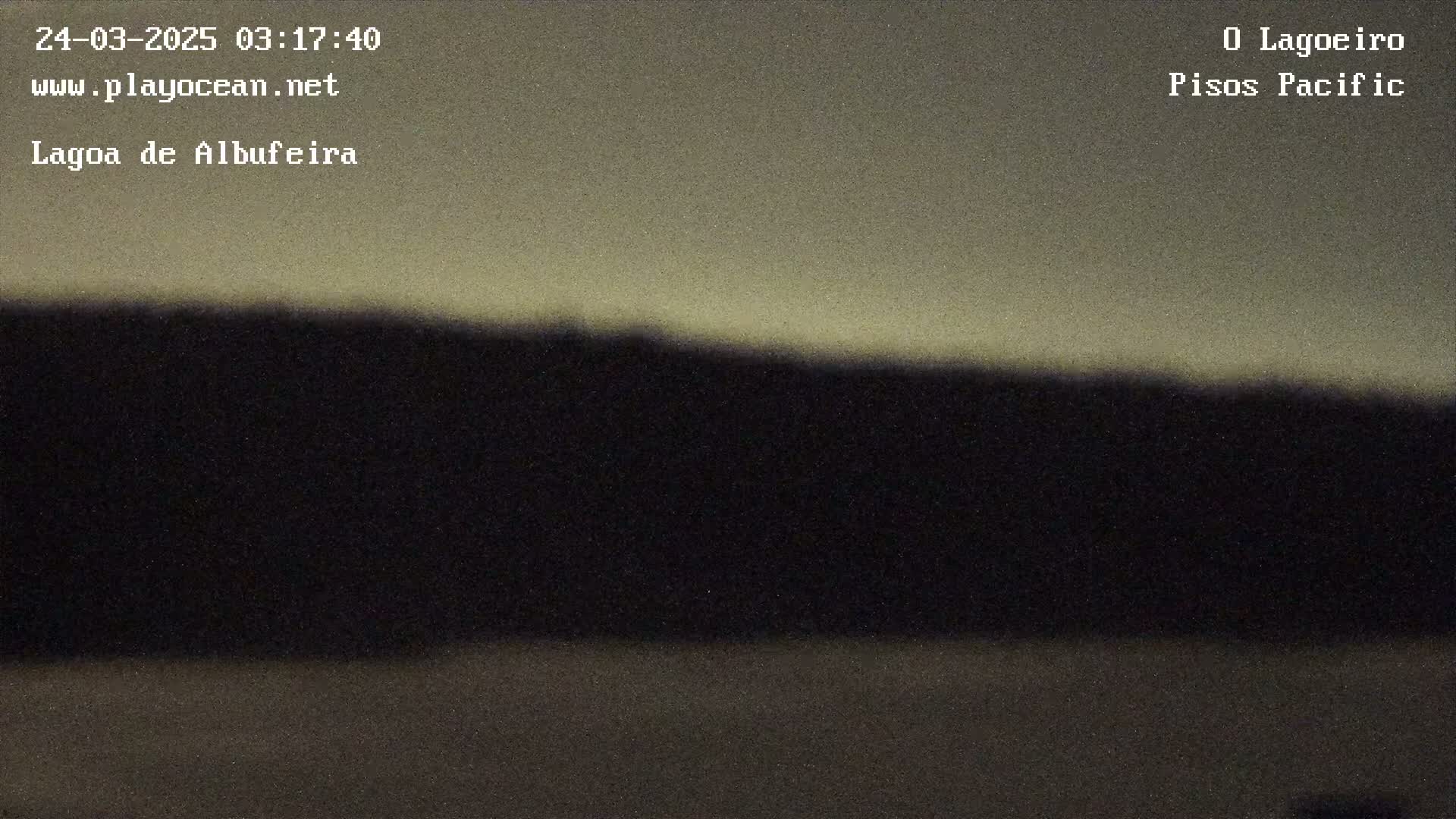 A dark, silhouetted landmass is visible against a light, muted sky.