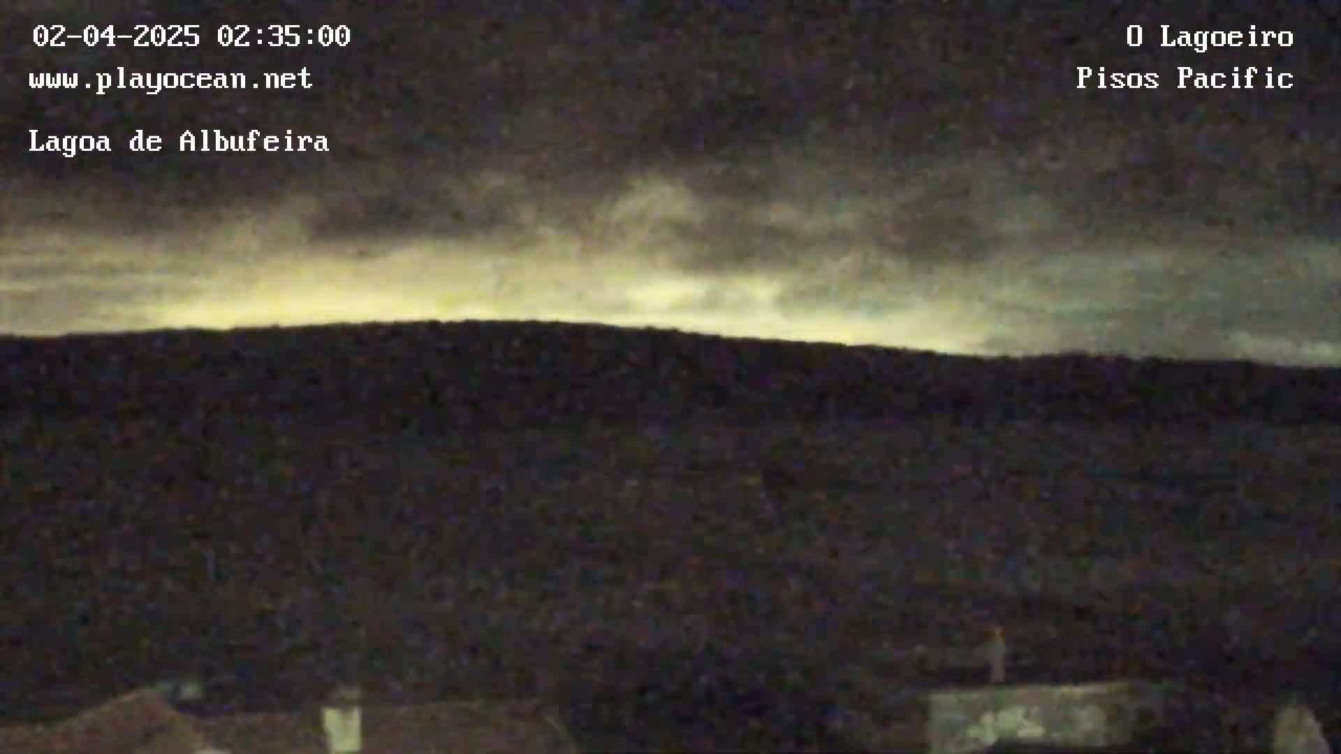 A nighttime, overcast scene shows a dark, flat landscape under a pale, yellowish-gray sky.