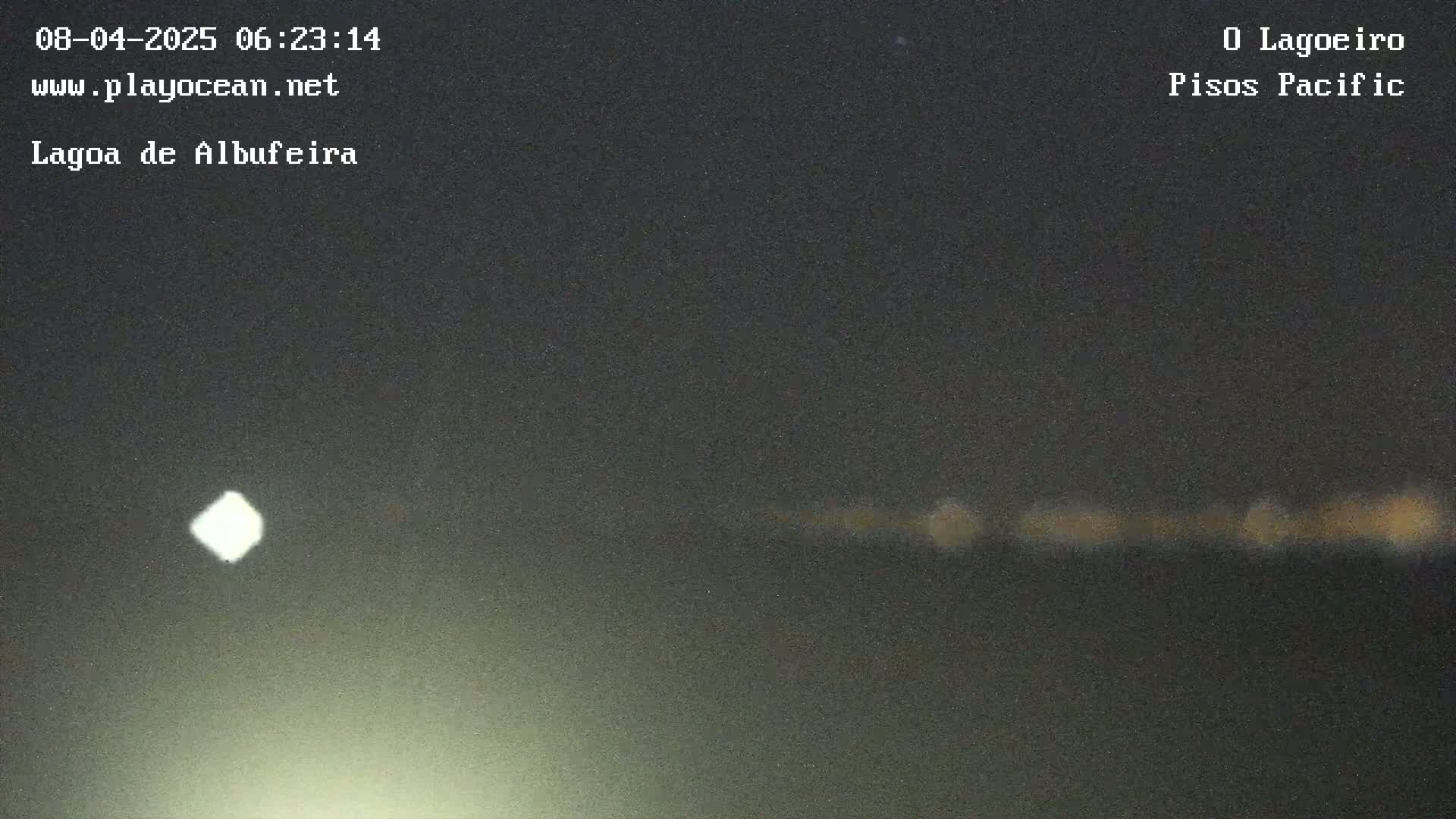 A nighttime long shot shows a dimly lit horizon line with a bright light in the sky.