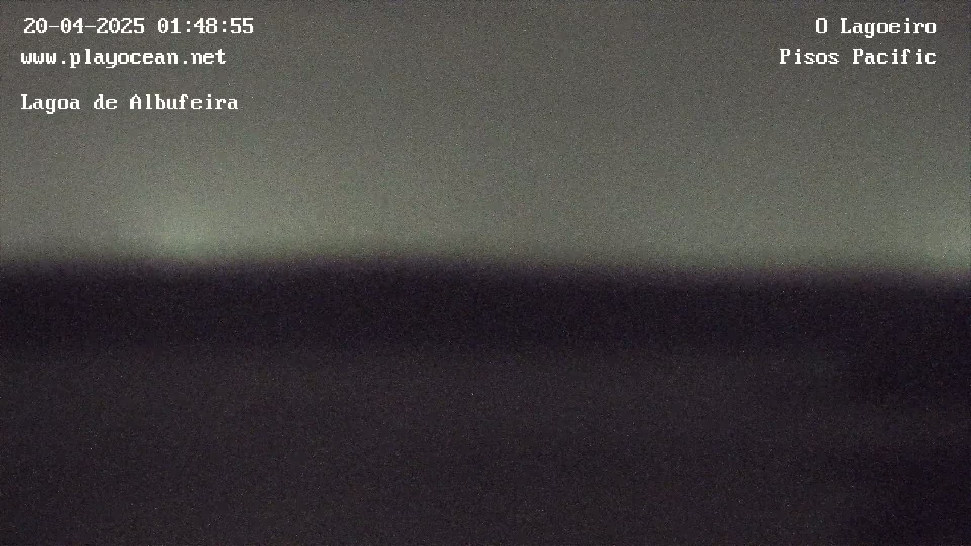 A dark, possibly nighttime, landscape shows a horizon line separating a slightly lighter sky from a darker ground.